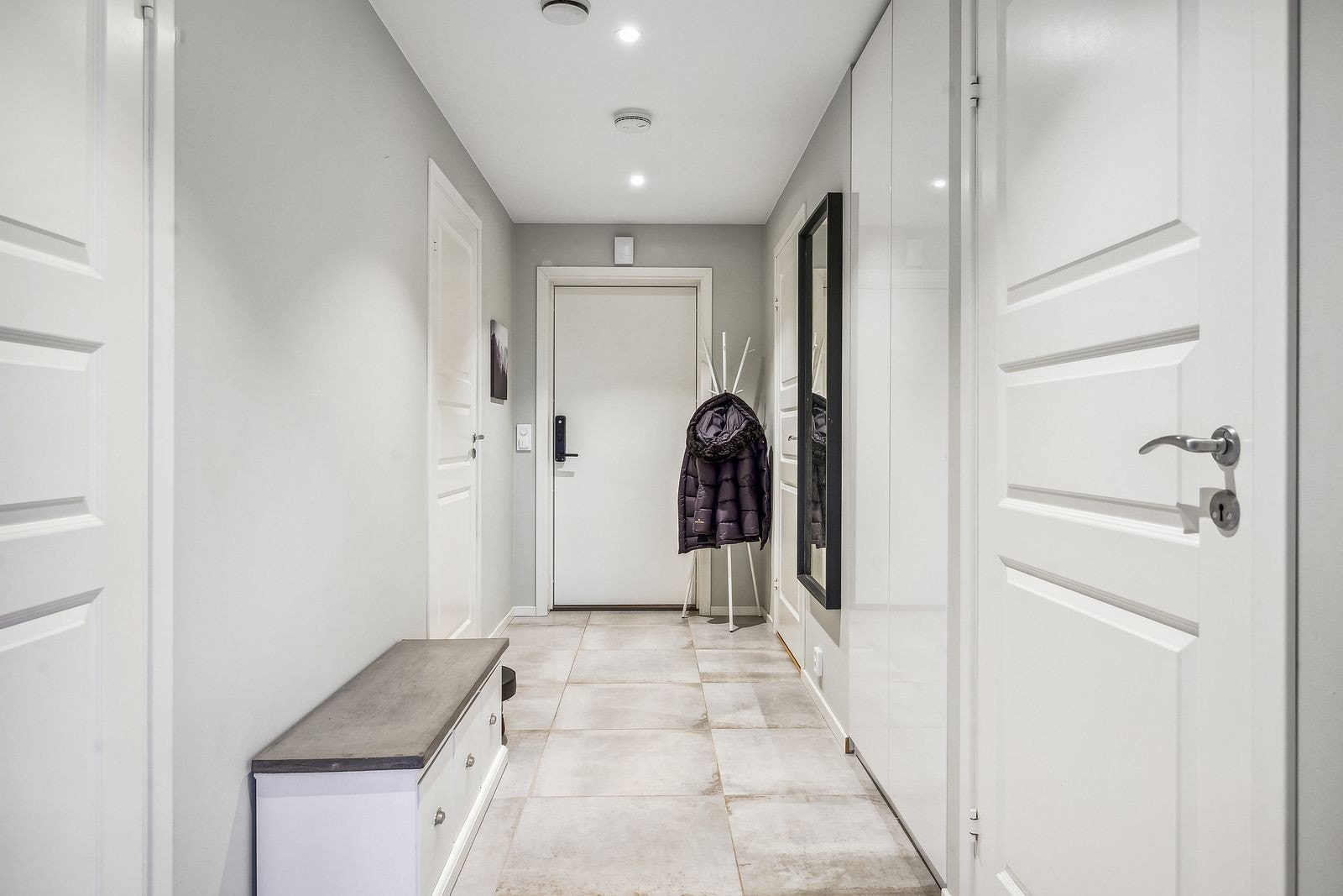 Entre med plass for oppheng av yttertøy. Flislagt gulv. Galleribilde