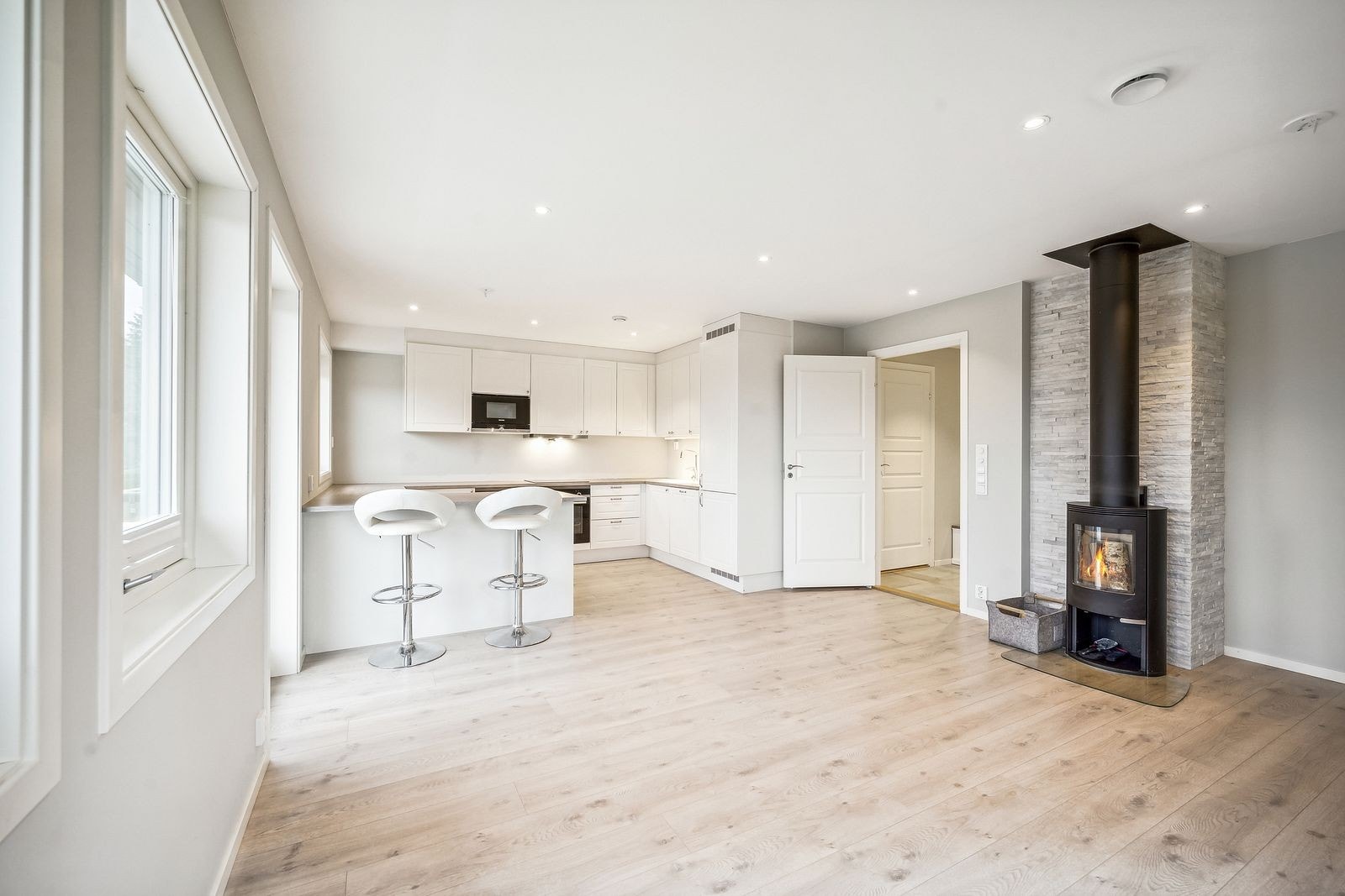 Stue og kjøkken i åpen løsning. I stuen er det peis. Her er det også plass til spisebord. Galleribilde