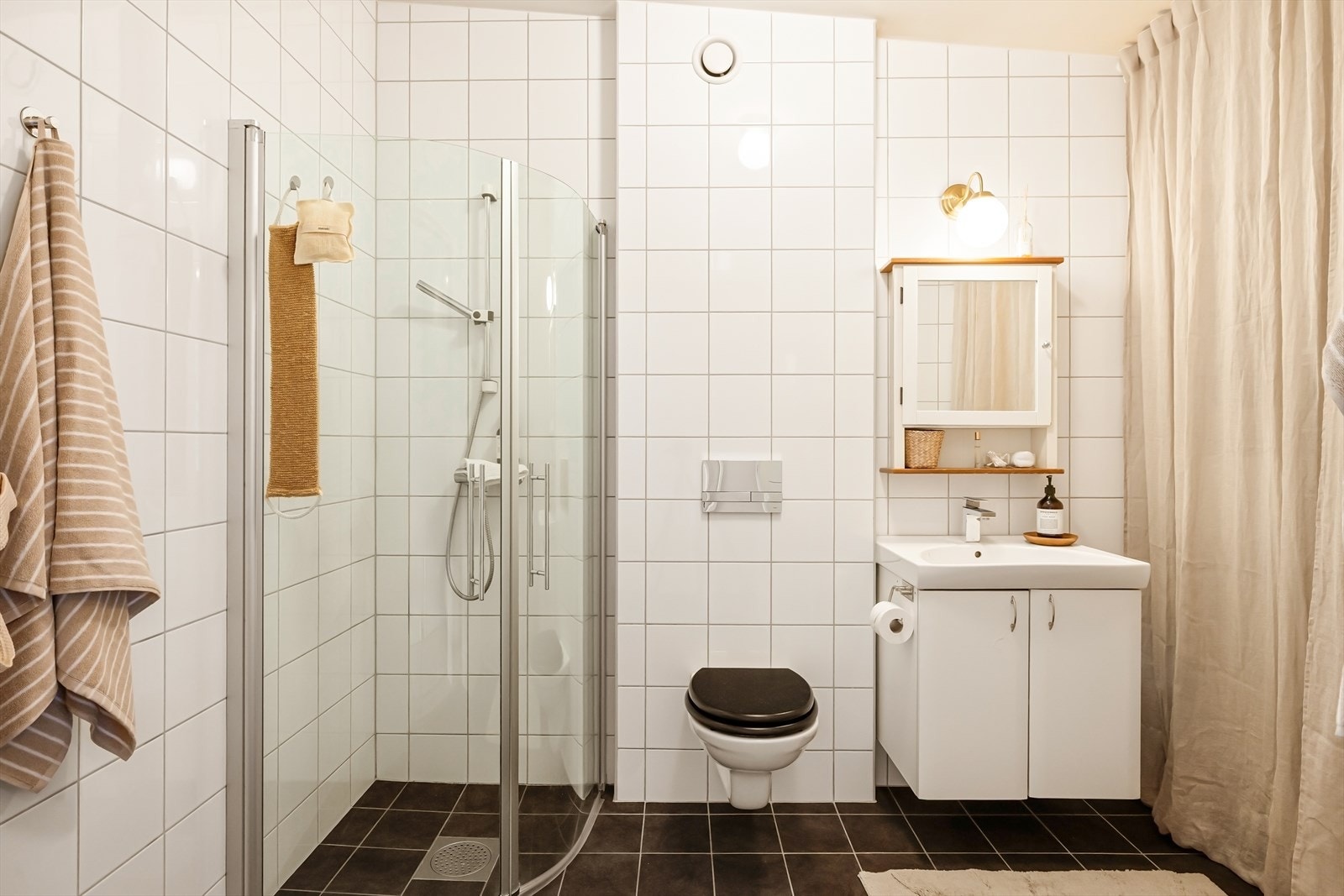 Helfliset bad med tidsriktige fargevalg og varmekabler i gulv. Lys og slett baderomsinnredning med heldekkende servant. Galleribilde