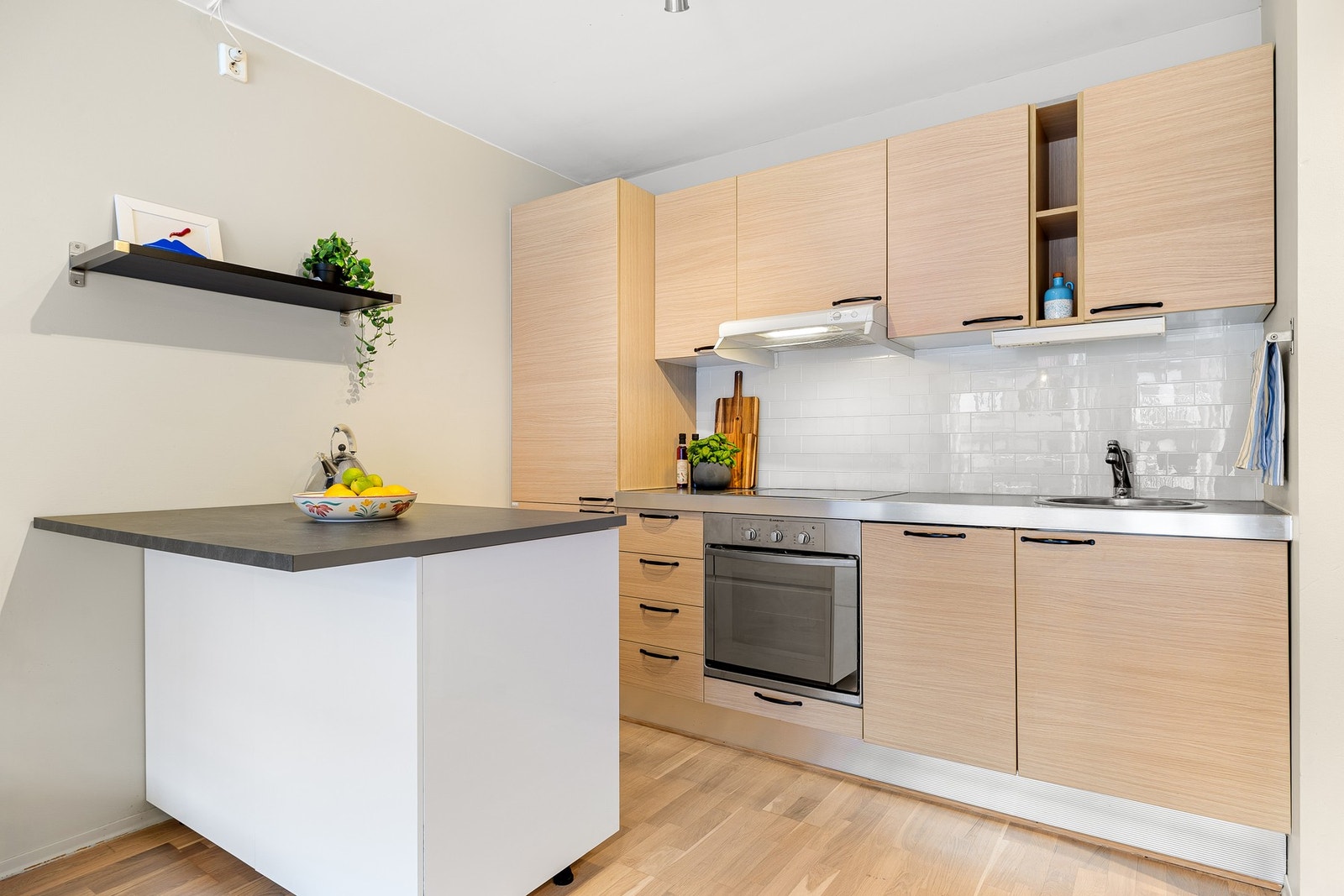 Flott og tidløst kjøkken med flis mellom over- og underskap. Integrert platetopp, stekeovn, oppvaskmaskin og kjøl/fryseskap medfølger i handelen. Galleribilde