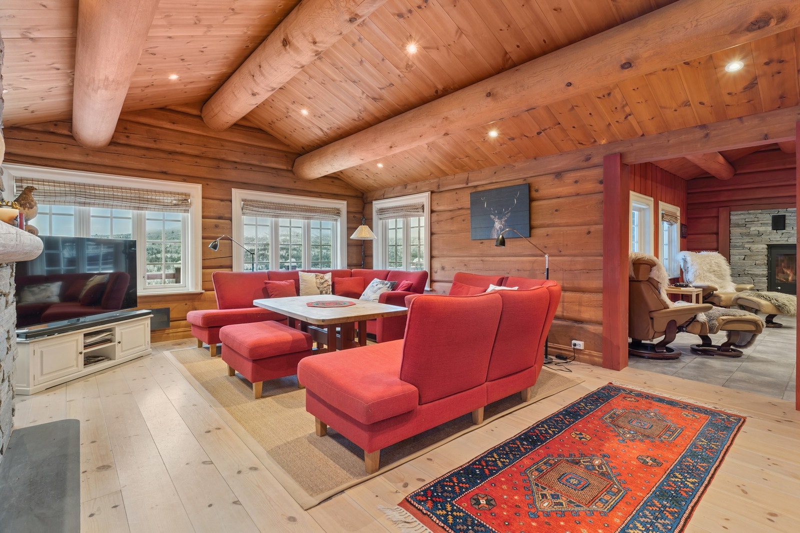 Lys og romslig stue med store vinduer som gir flott utsikt og naturlig lys. Galleribilde