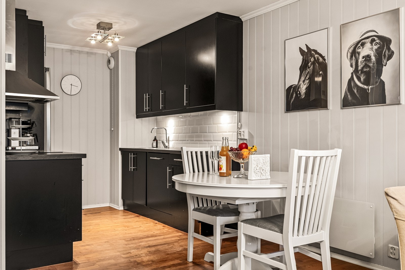 Moderne kjøkken i sort utførelse med fliser over benk Galleribilde