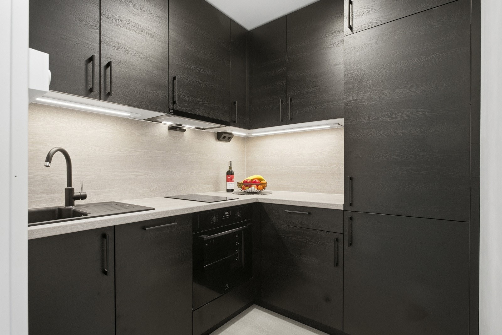 Stilrent kjøkken med slettefronter og mørke detaljer. Galleribilde