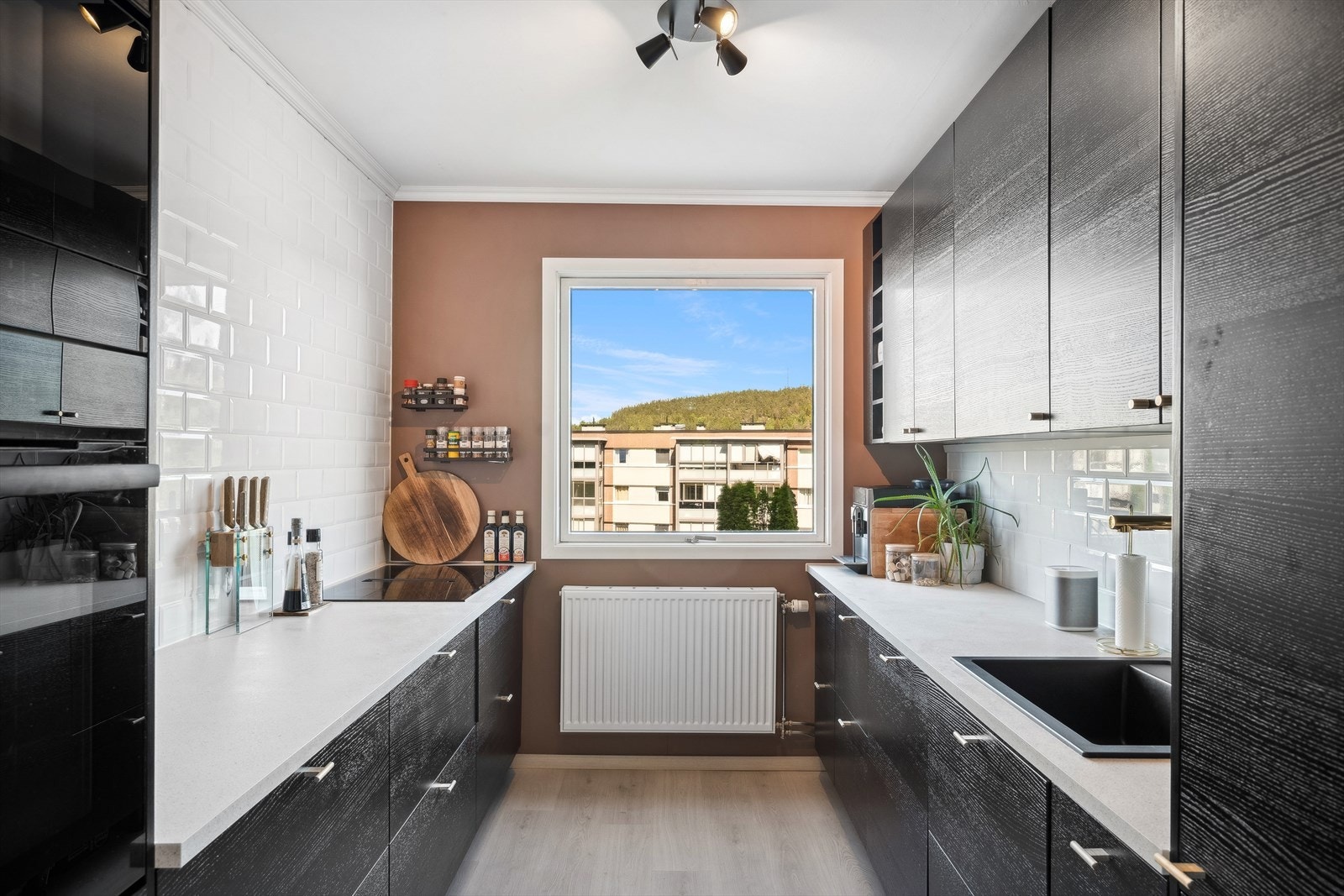 Moderne kjøkken med integrerte hvitevarer som kjøleskap, komfyrtopp, stekeovn og oppvaskmaskin. Galleribilde