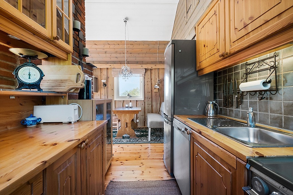 Kjøkkenet er utstyrt med hvitevarer i nisje og servant. Galleribilde