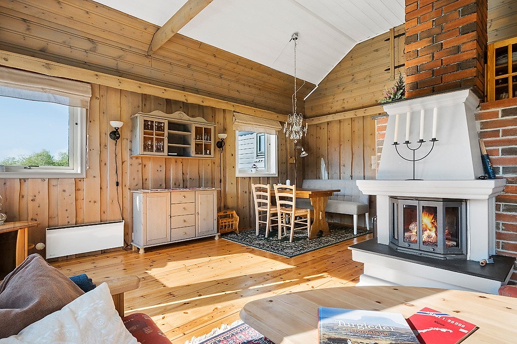 Sentralt i stuen står en klassisk muret peis som utstråler både varme og hyttestemning. Galleribilde