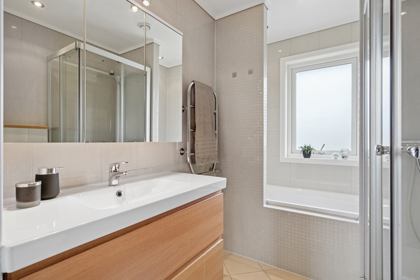 Baderommet i hovedetasjen har praktisk dusjløsning med glassdører og i tillegg et innbydende badekar. Galleribilde