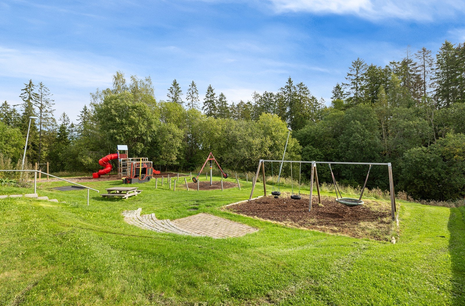 Fellesarealene er opparbeidet med plen, beplantning/ prydbusker, uteboder og lekeplasser. Galleribilde