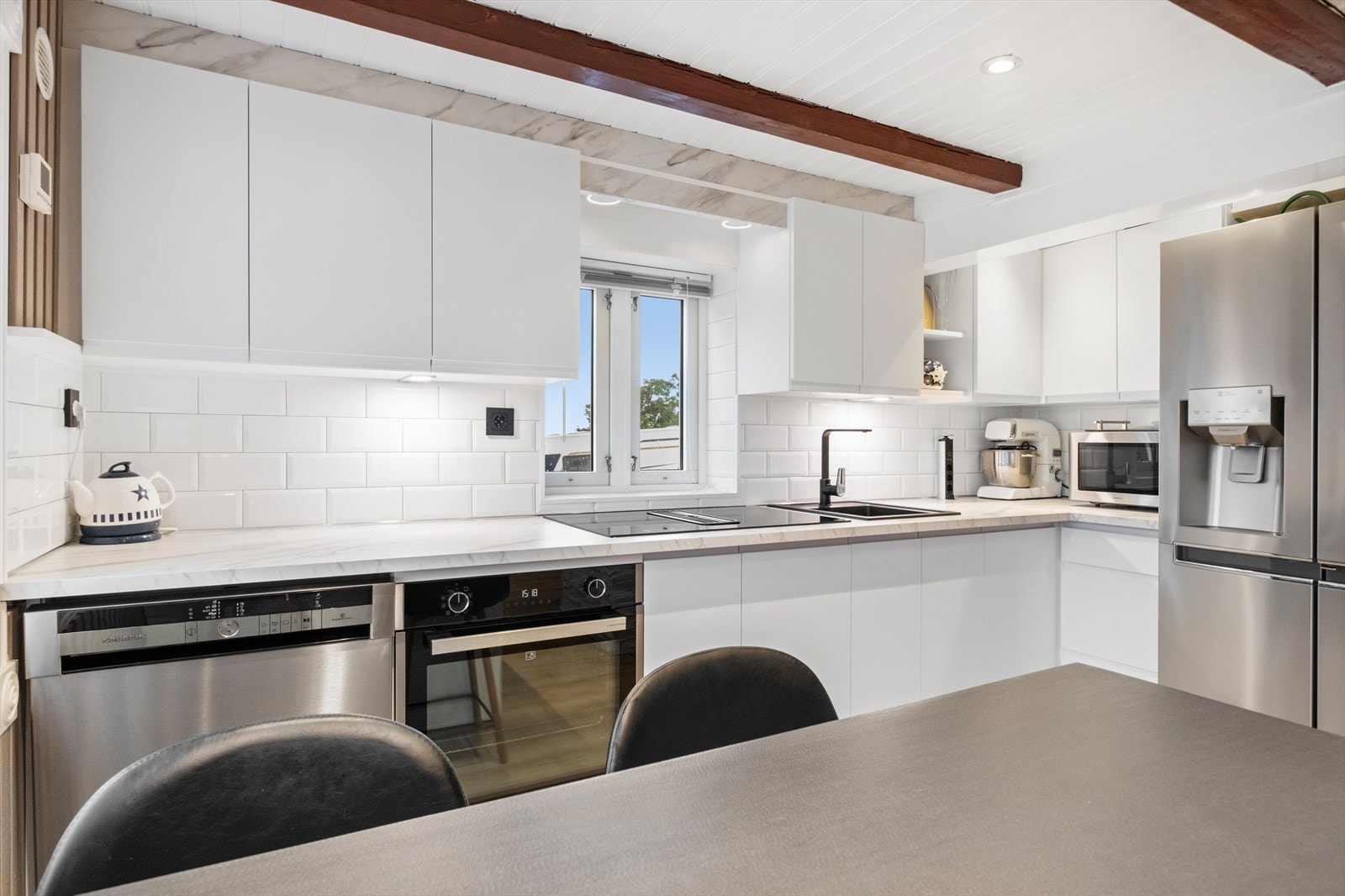 Lys og moderne kjøkkeninnredning fra Kvik med slette fronter. Galleribilde