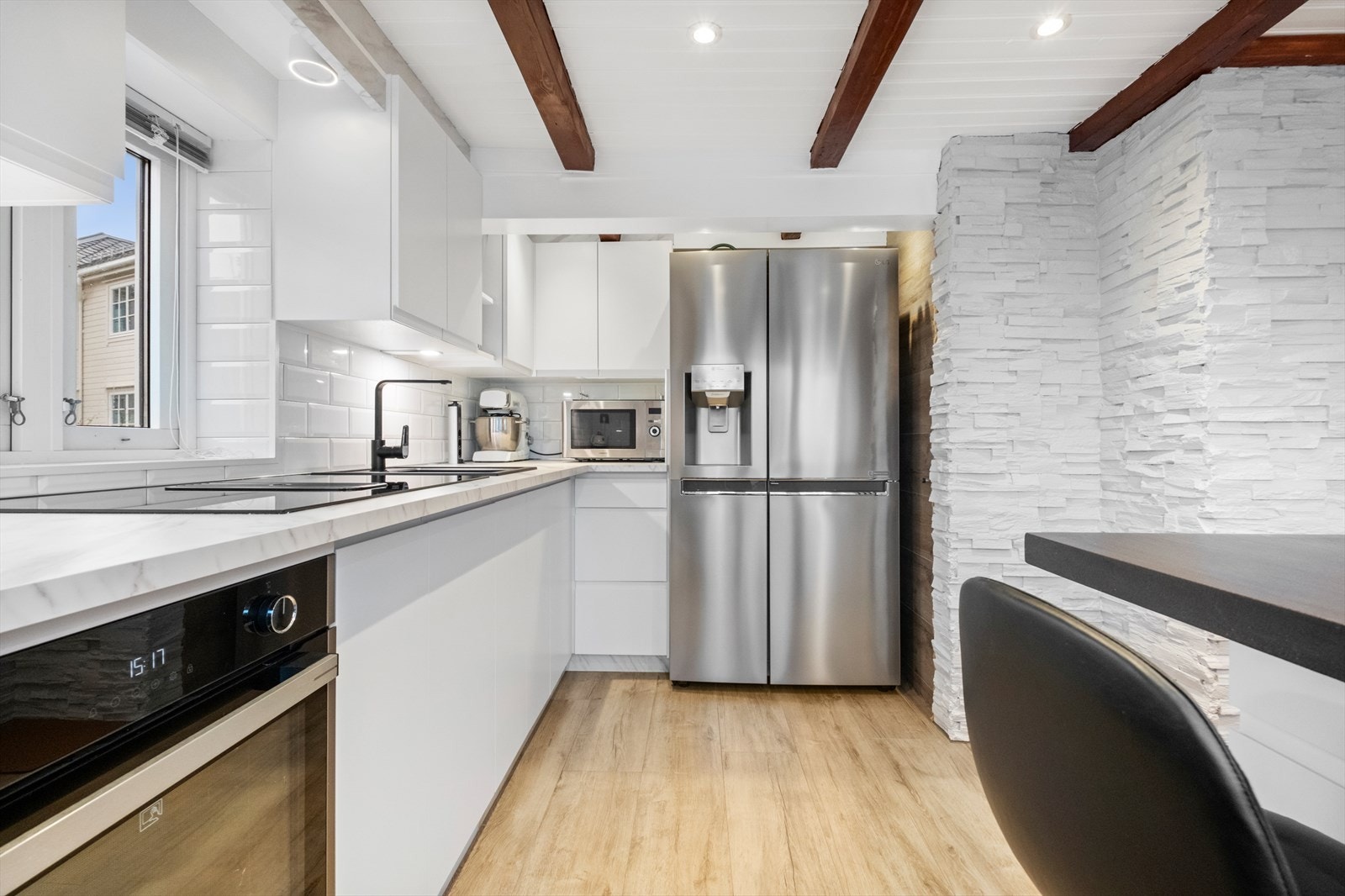 Det er fliser mellom benk og overskap, samt laminat benkeplate med nedfelt oppvaskkum. Galleribilde