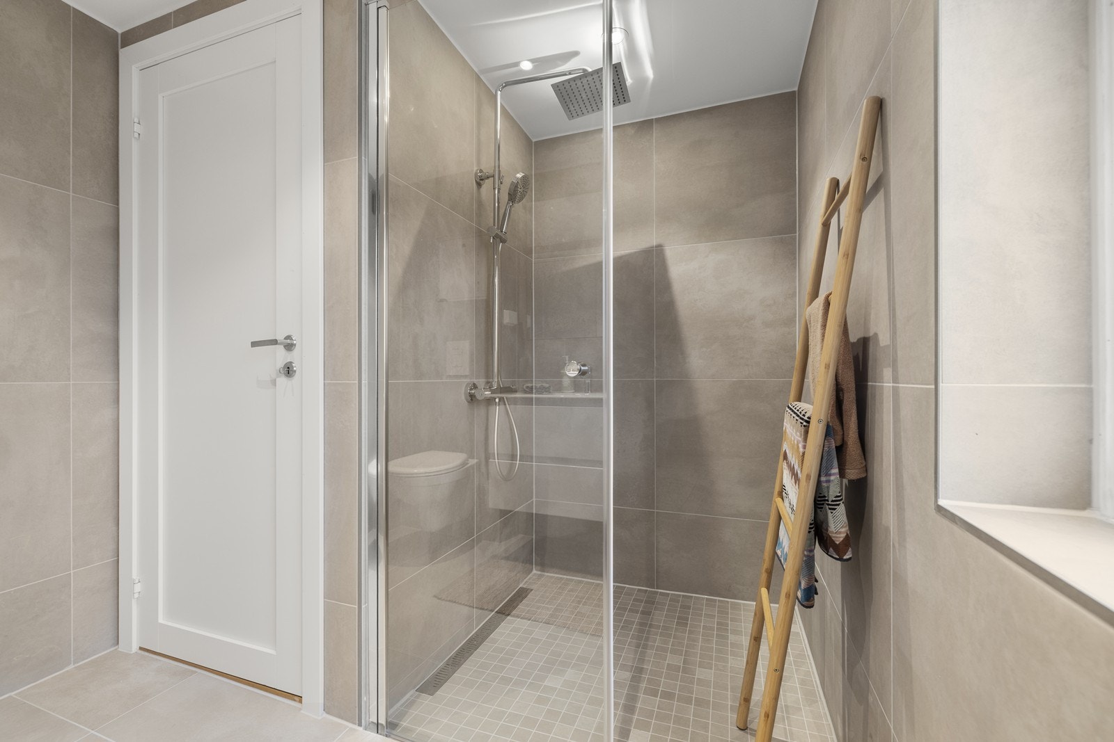 Badet er utstyrt med dusjhjørne med regnfallsdusj og elektrisk gulvvarme for økt komfort. Galleribilde