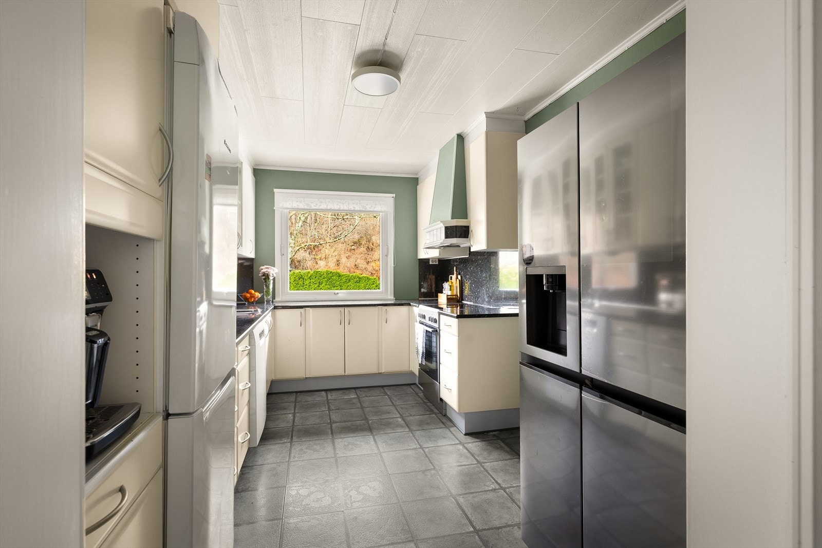 Kjøl/fryseskap og oppvaskmaskin gir praktiske løsninger for matlagring. Galleribilde