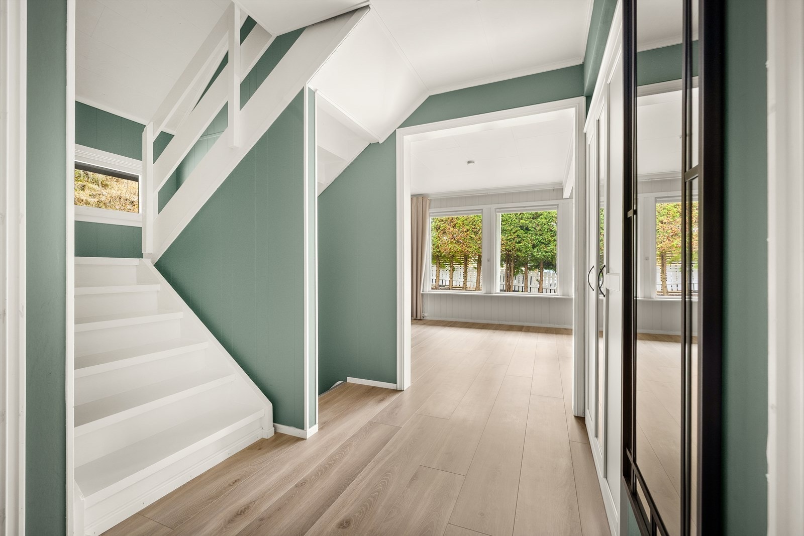 Store vindusflater gir rikelig med naturlig lys i stuen. Galleribilde