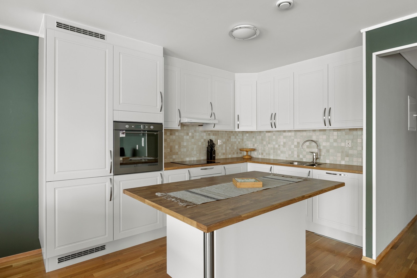 Stilren innredning med integrert stekeovn, platetopp, kjøl-/fryseskap og oppvaskmaskin Galleribilde