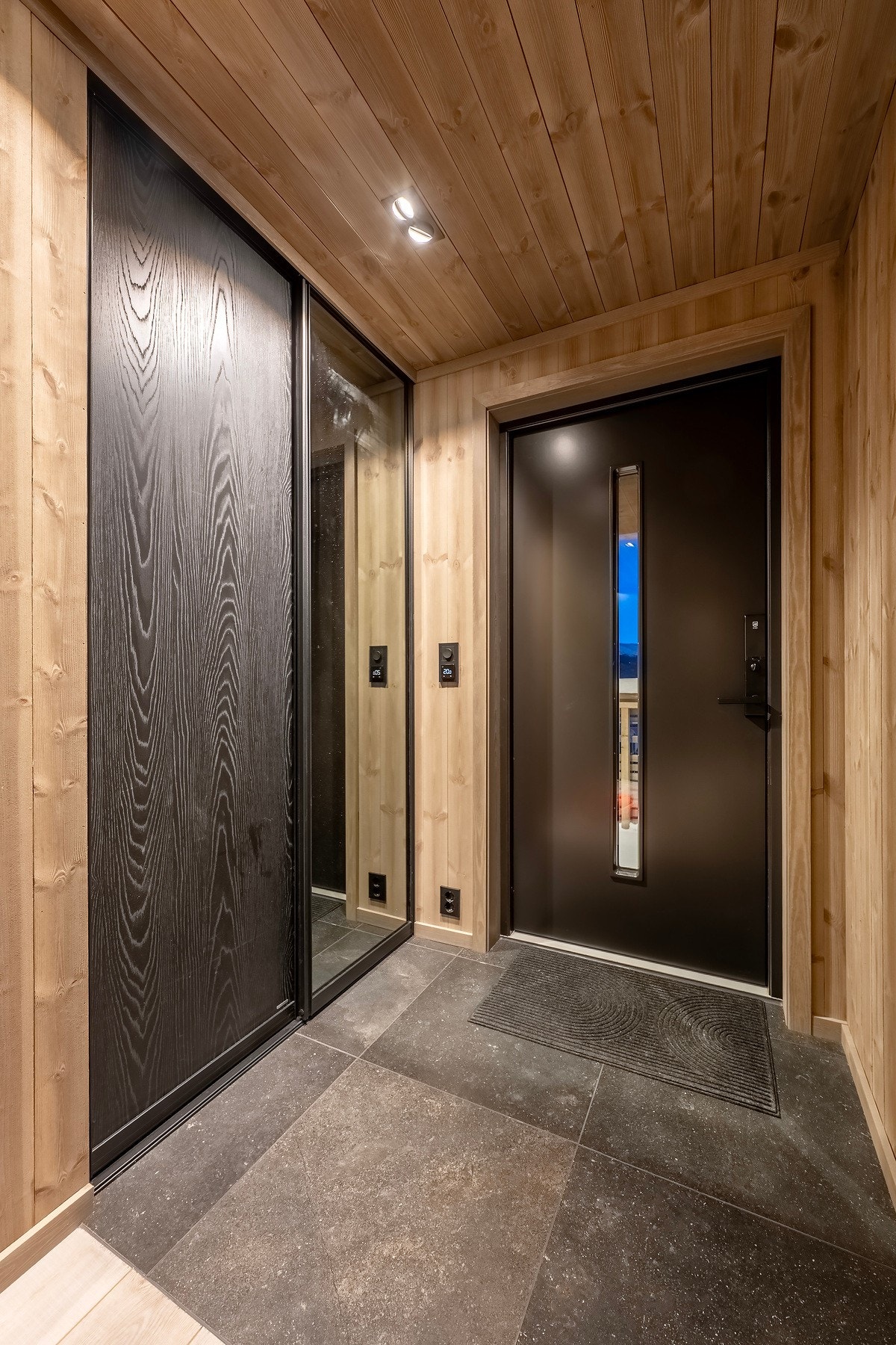 Flislagt entré med innredet skyvedørsgarderobe. Galleribilde