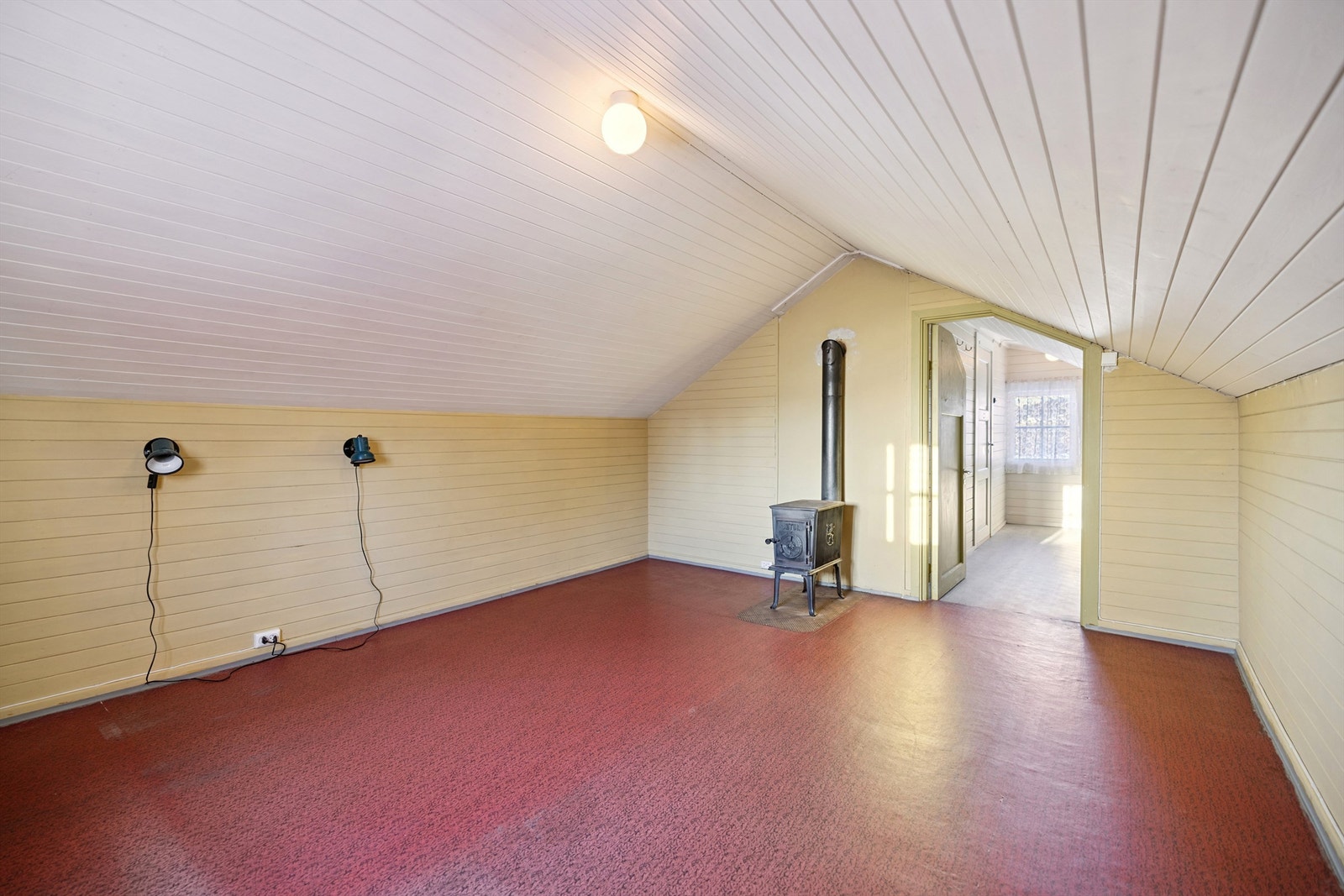 Rommet har skråtak som gir en lun atmosfære, og malt trepanel. Galleribilde