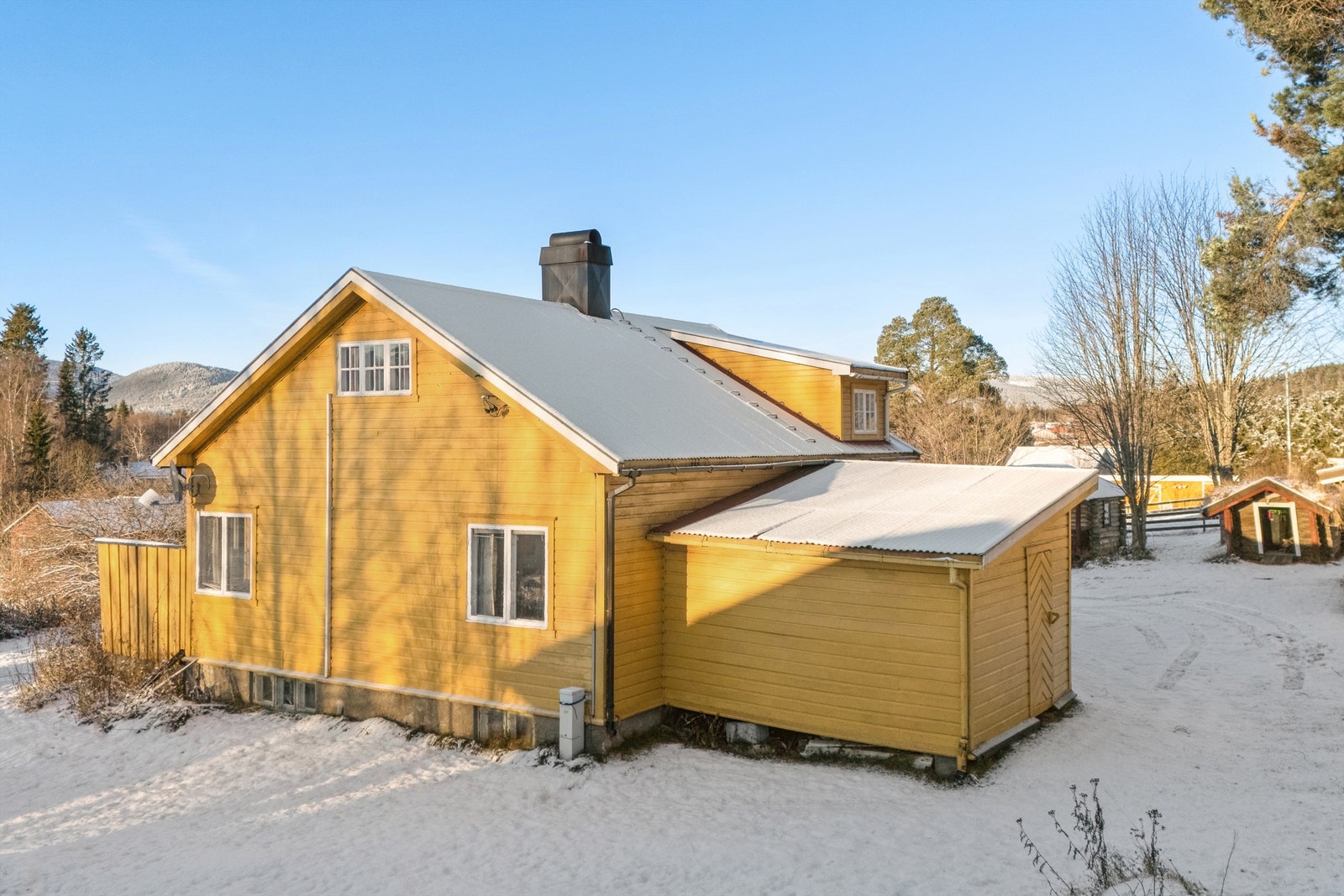 Boligen har utvendig liggende kledning og saltak tekket med metallplater. Galleribilde