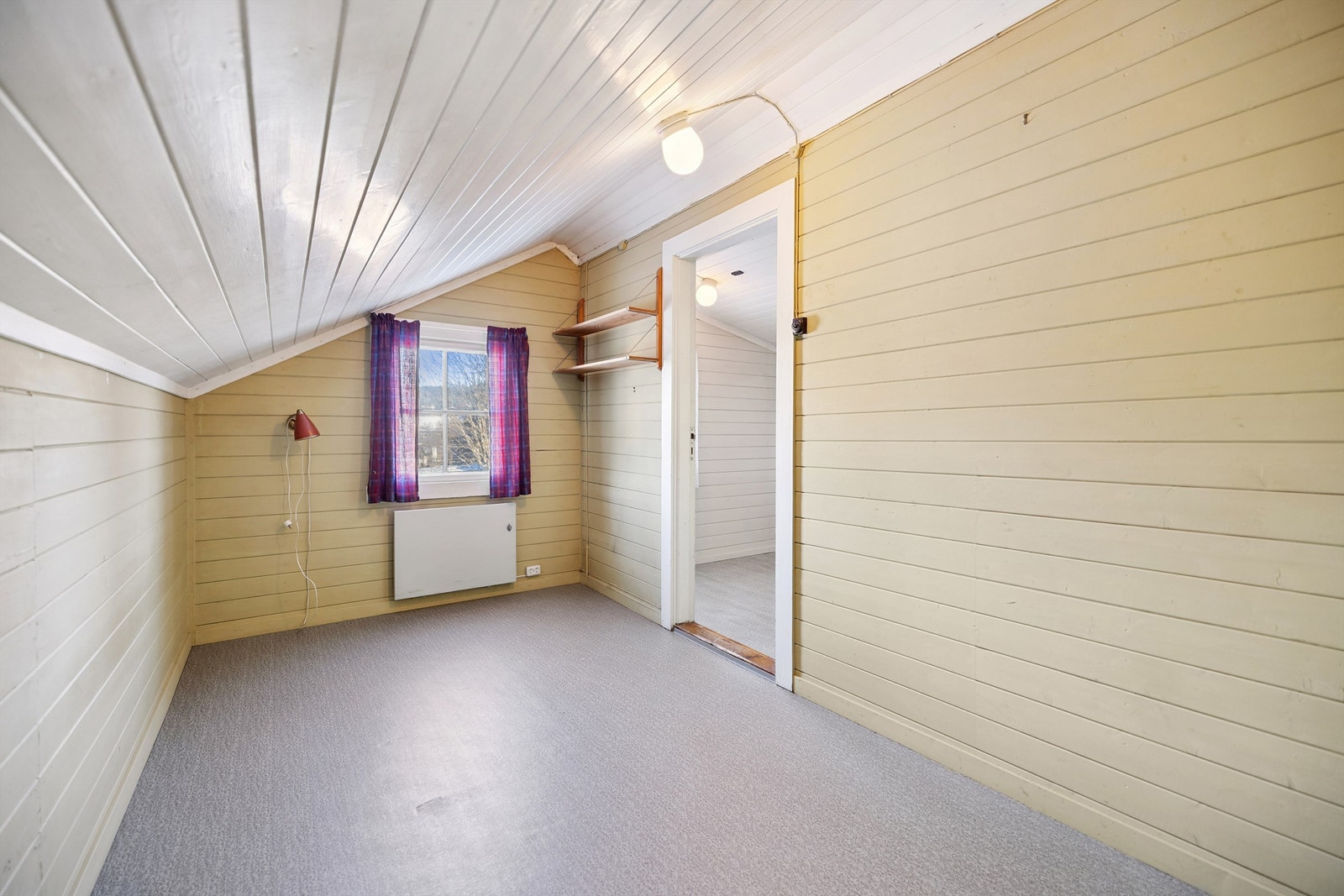 Det andre soverommet i etasjen har også skråtak og plass til seng og oppbevaring. Galleribilde