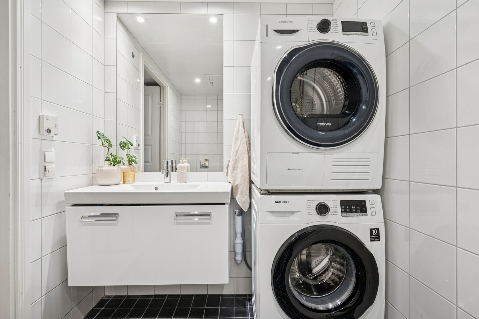 Bad i leilighetens 1. etasje. Flislagt gulv med varme og flislagte vegger. Innredning med servant med ett-greps armatur. Innmurt speil samt dobbel stikkontakt på vegg. Galleribilde