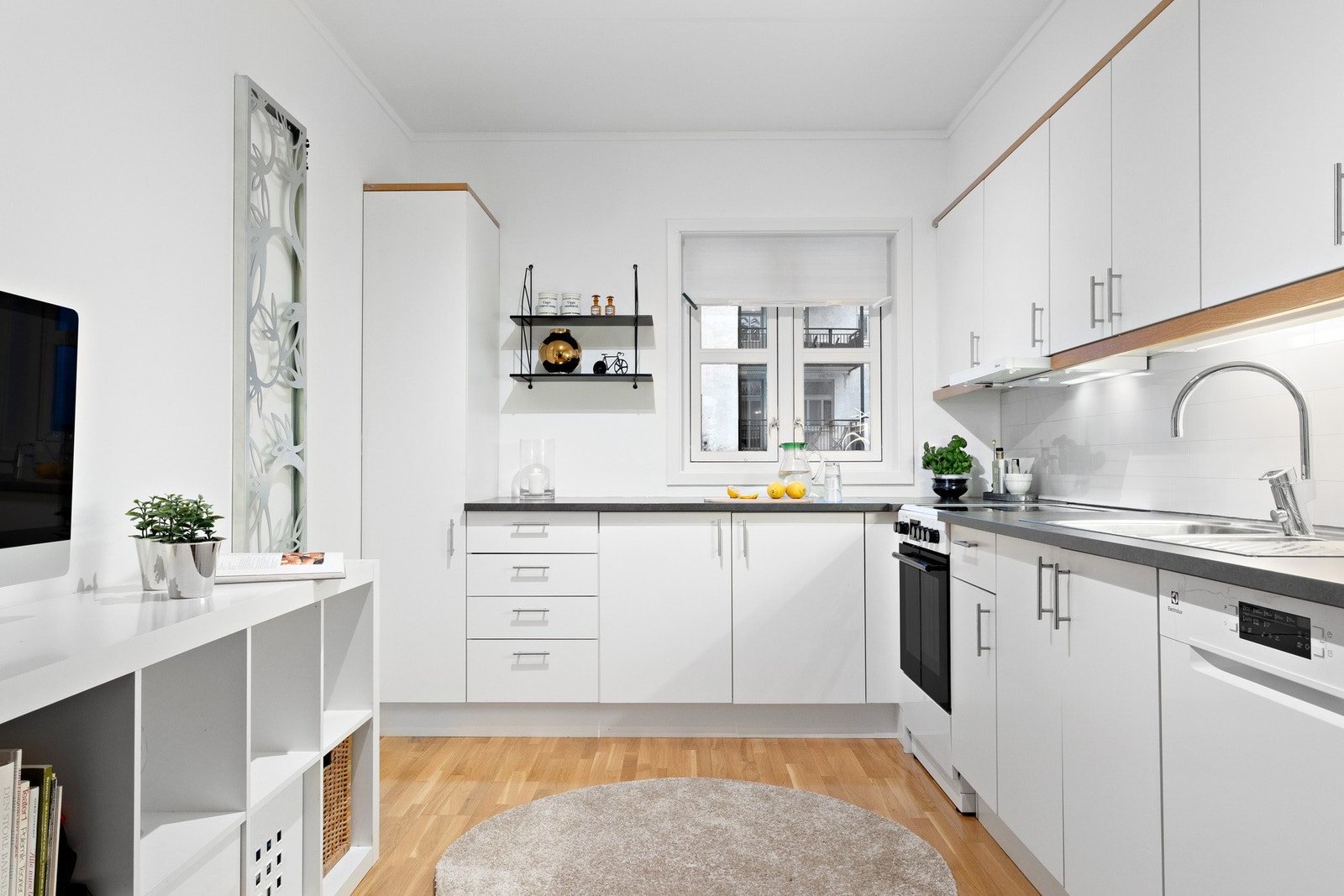 Kjøkken i tidløs utførelse med hvite slette fronter. Her tilbys rikelig med lagringsplass i over- og underskap. Galleribilde