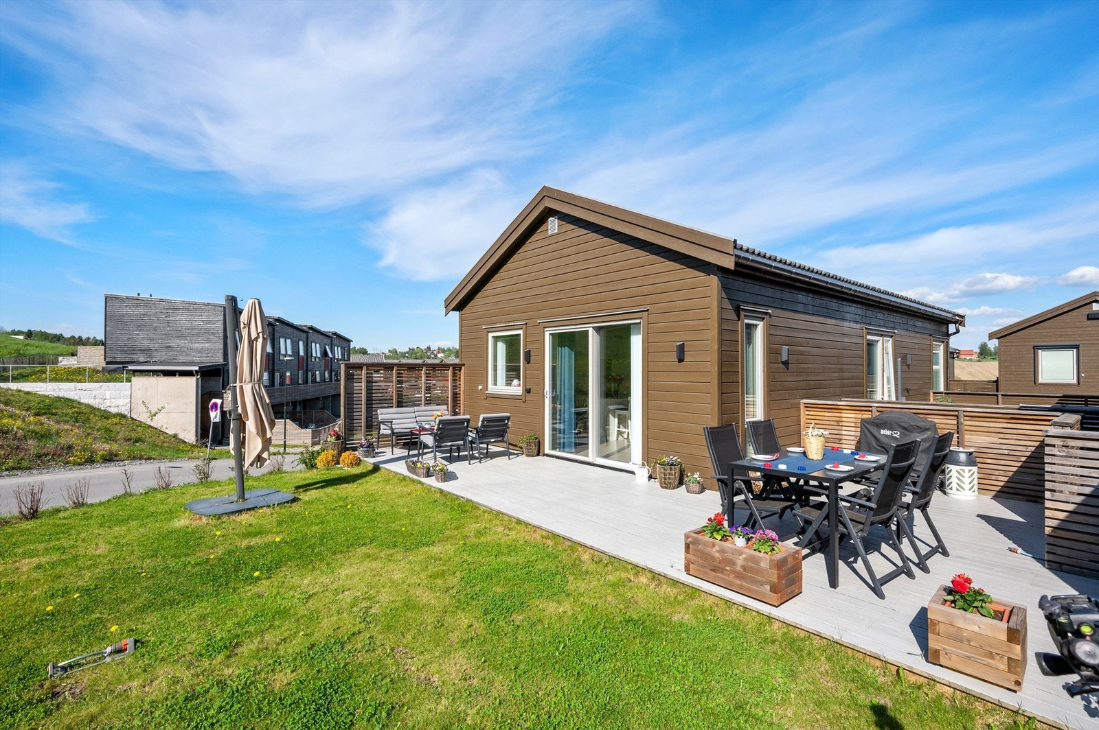 Pent opparbeidet tomt med asfaltert gårdsplass og plenareal. Galleribilde