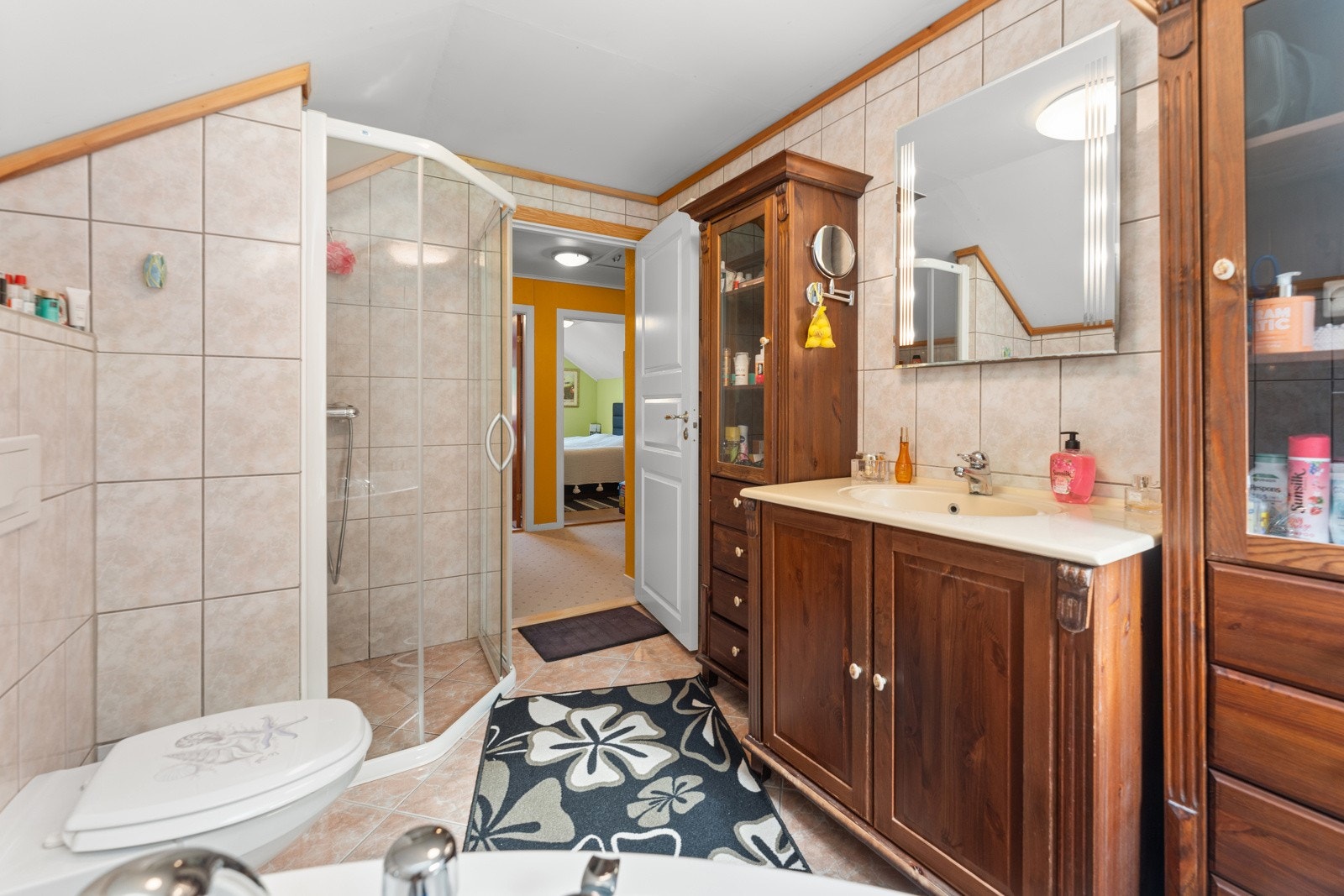 Flislagt bad med baderomsinnredning med mye skapplass. Galleribilde