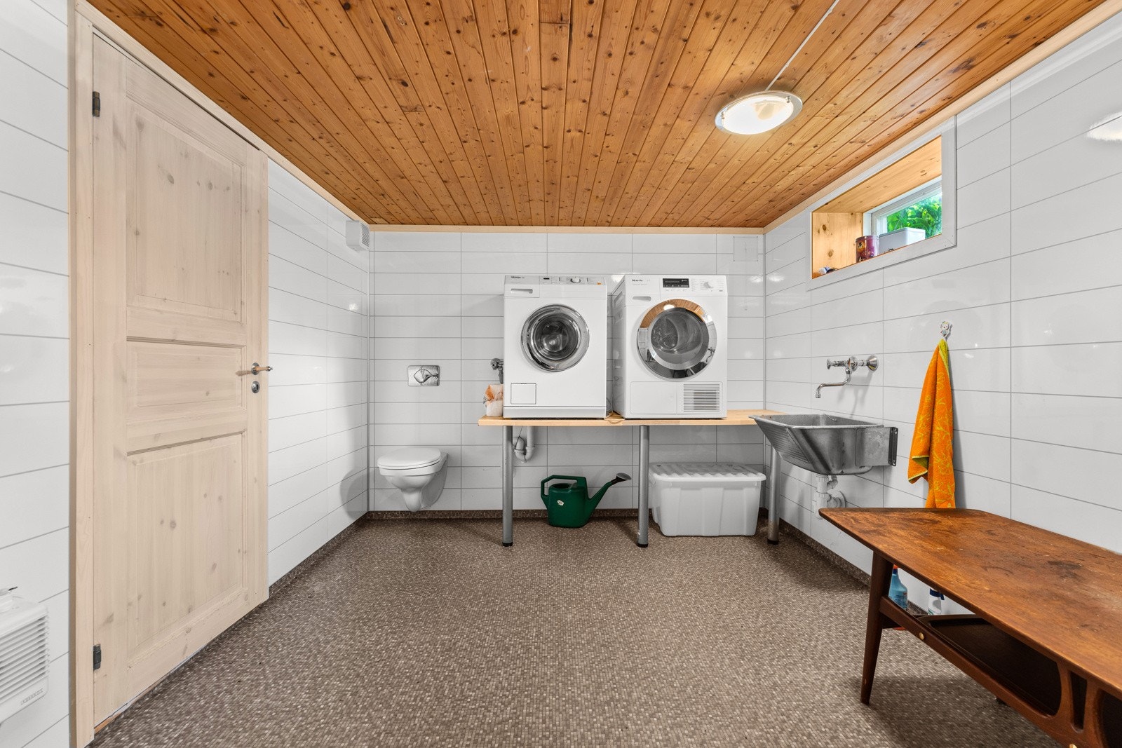Vaskerommet er romslig med vegghengt toalett, utslagsvask og god plass til vaskemaskin og tørketrommel. Galleribilde