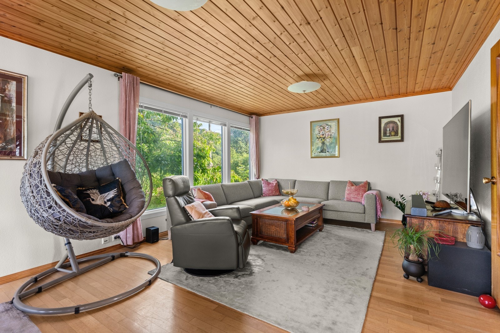 Stuen er malt i en lys farge og har parkett på gulv. Store vindusflater mot hagen. Galleribilde