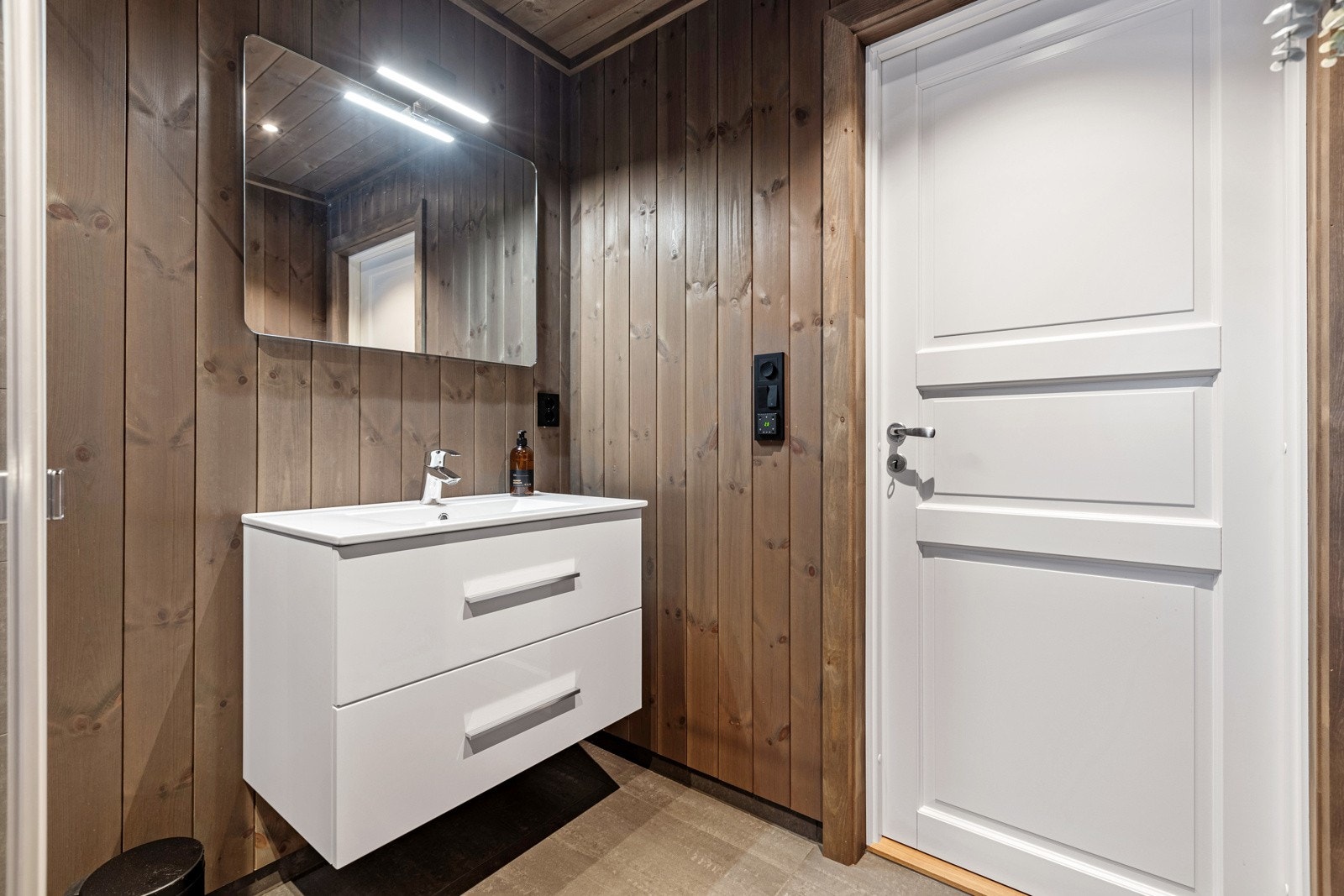 Begge badene er innredet med et veggmontert toalett, servant, og et dusjhjørne. Galleribilde