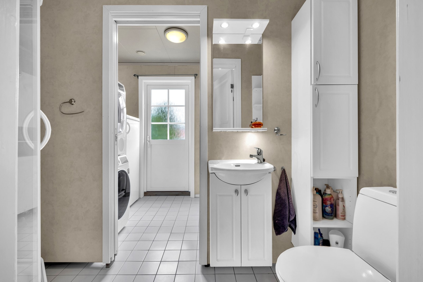 I første etasje finner du et kombinert bad og vaskerom med flislagt gulv og direkte utgang til hagen. Galleribilde
