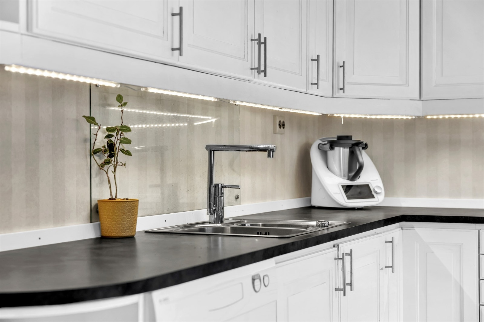 Kjøkkenet har ellers profilerte fronter, laminert benkeplate og praktisk glassplate på vegg over oppvaskkum og platetopp. Galleribilde