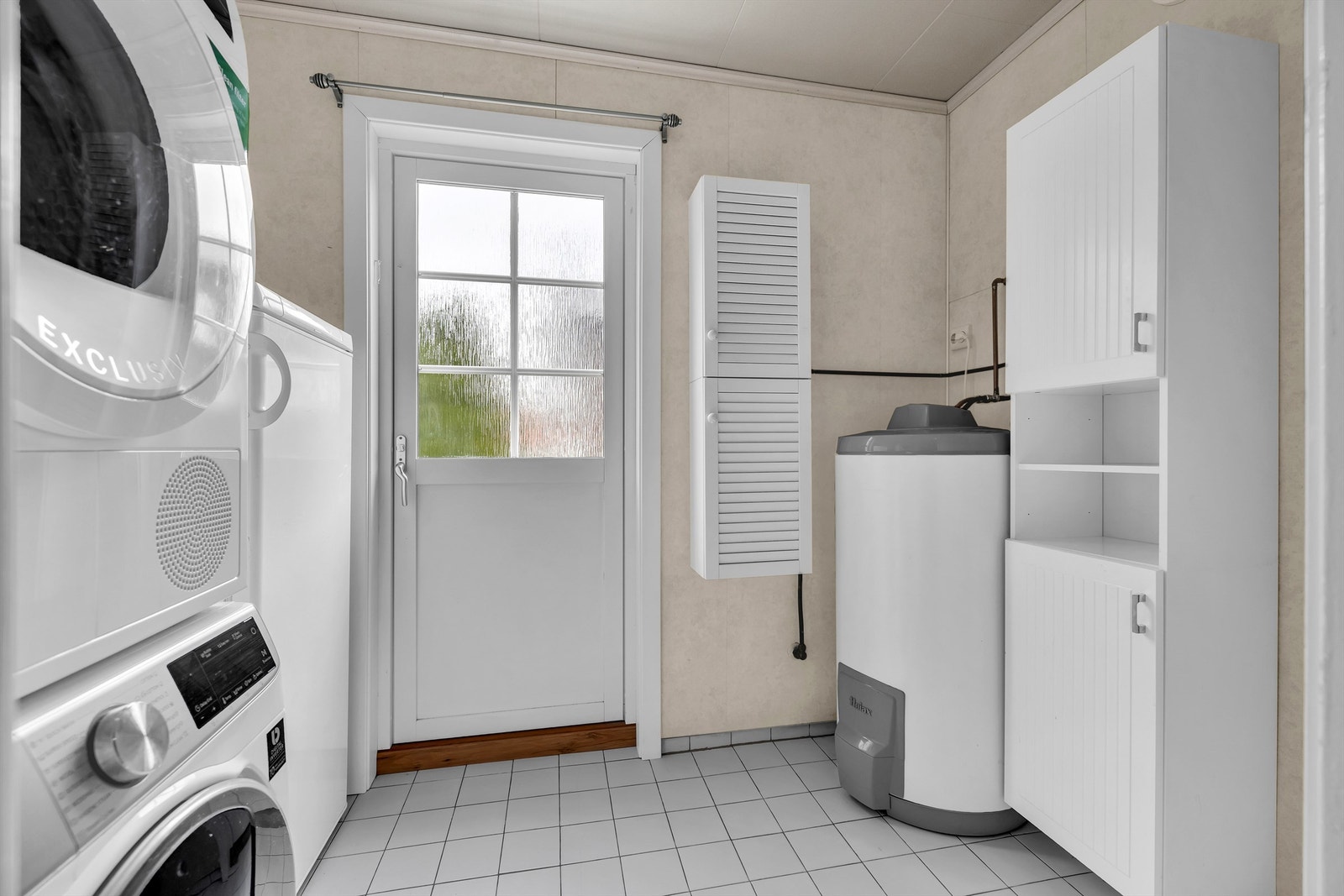 Rommet er utstyrt med gulvstående toalett, dusjkabinett med glassdører og et vegghengt servantskap. Galleribilde