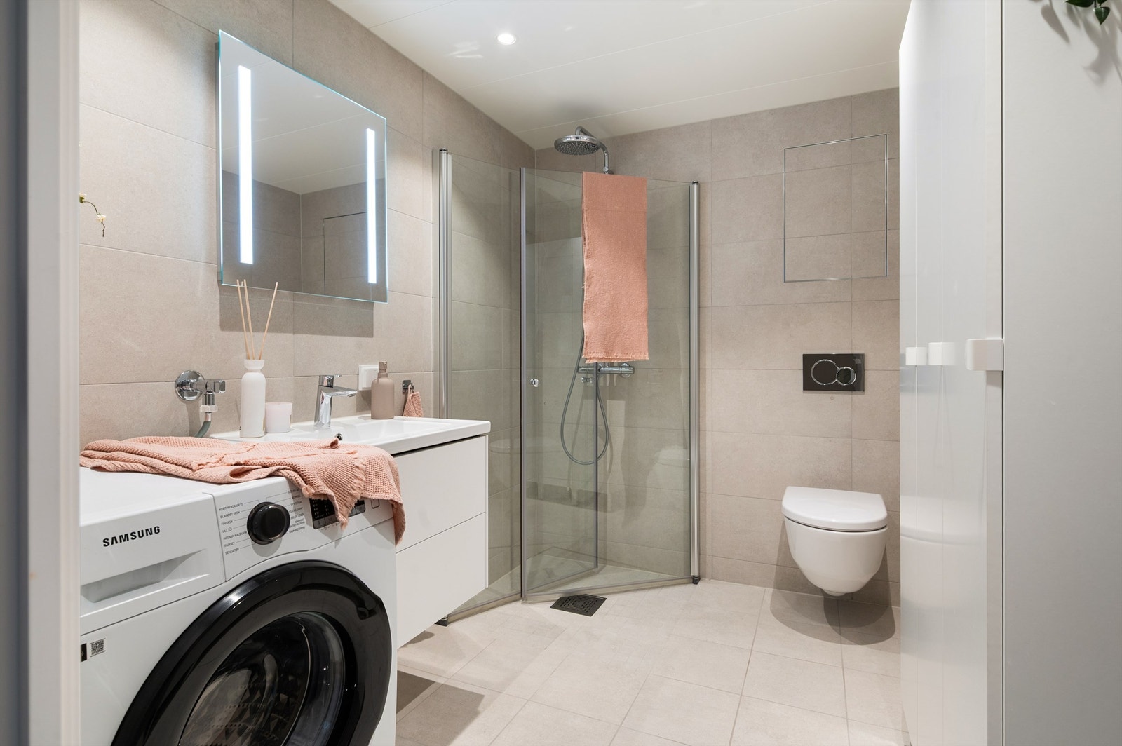 Badet er pent flislagt på gulv og vegger. Varme i gulvet sørger for en behagelig start på dagen Galleribilde