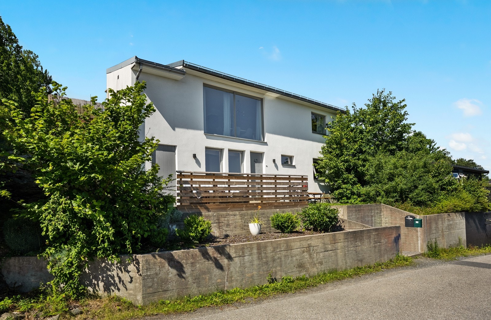 Tomten er opparbeidet med støttemurer, gressplen, diverse bed og beplantning, prydbusker m.m. Galleribilde