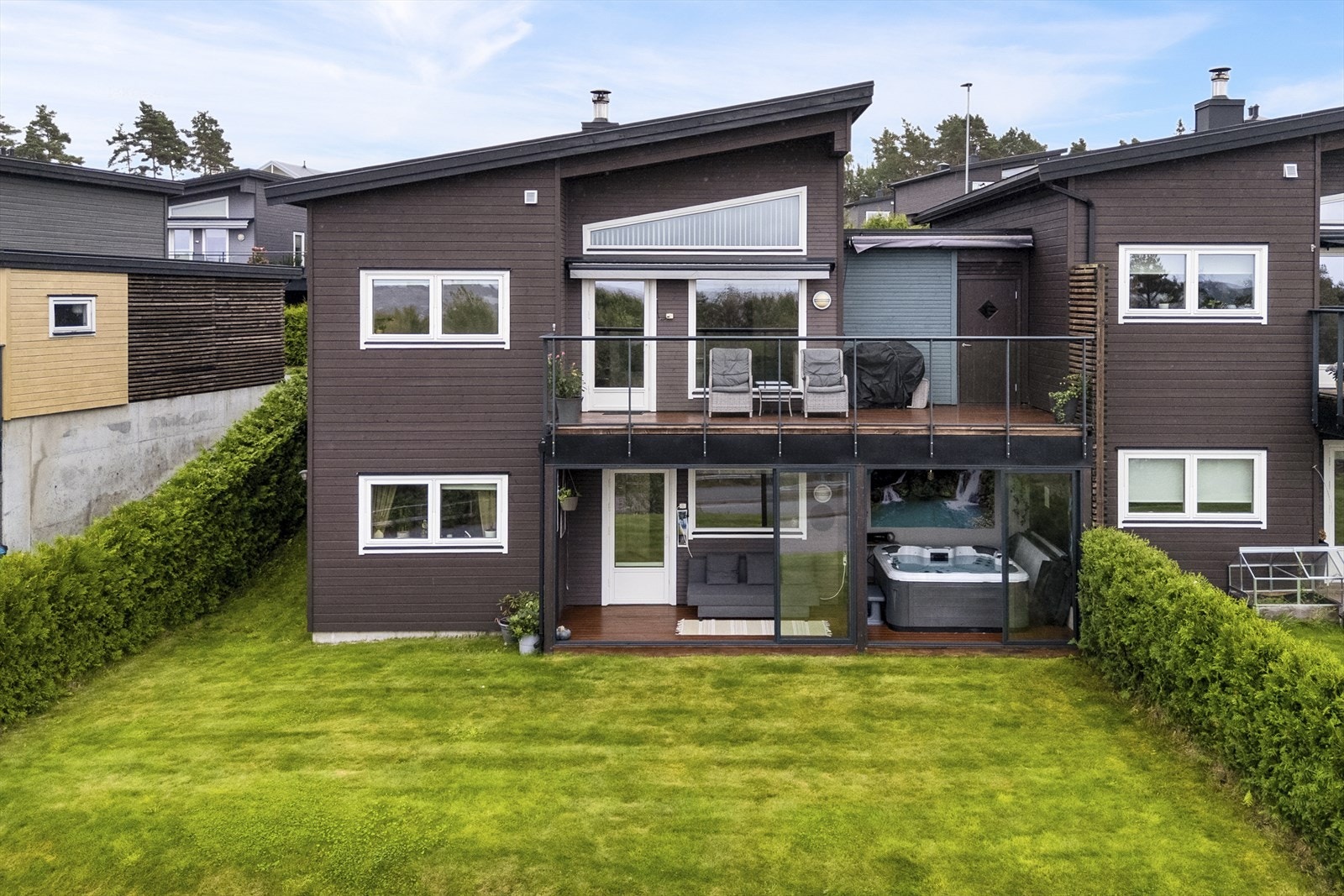 Ute. Fra terrassen i hovedetasjen er det praktisk gjennomgang til garasjen. Inne i garasjen finnes det en romslig bod, praktisk til lagring av feks hagemøbler Galleribilde