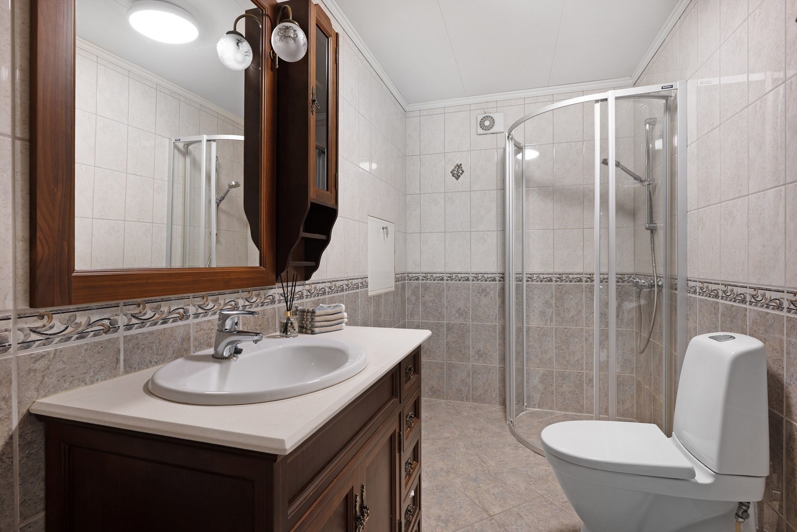 Badet har dusjvegger og innredning med servant. Galleribilde