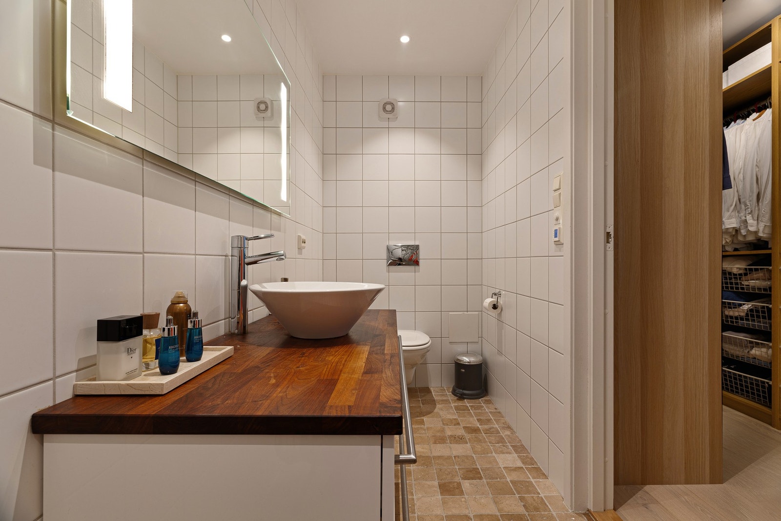 Bad fra byggeår ved soverom er innredet med dusj, servantskål m/skuffeseksjon og vegghengt toalett Galleribilde