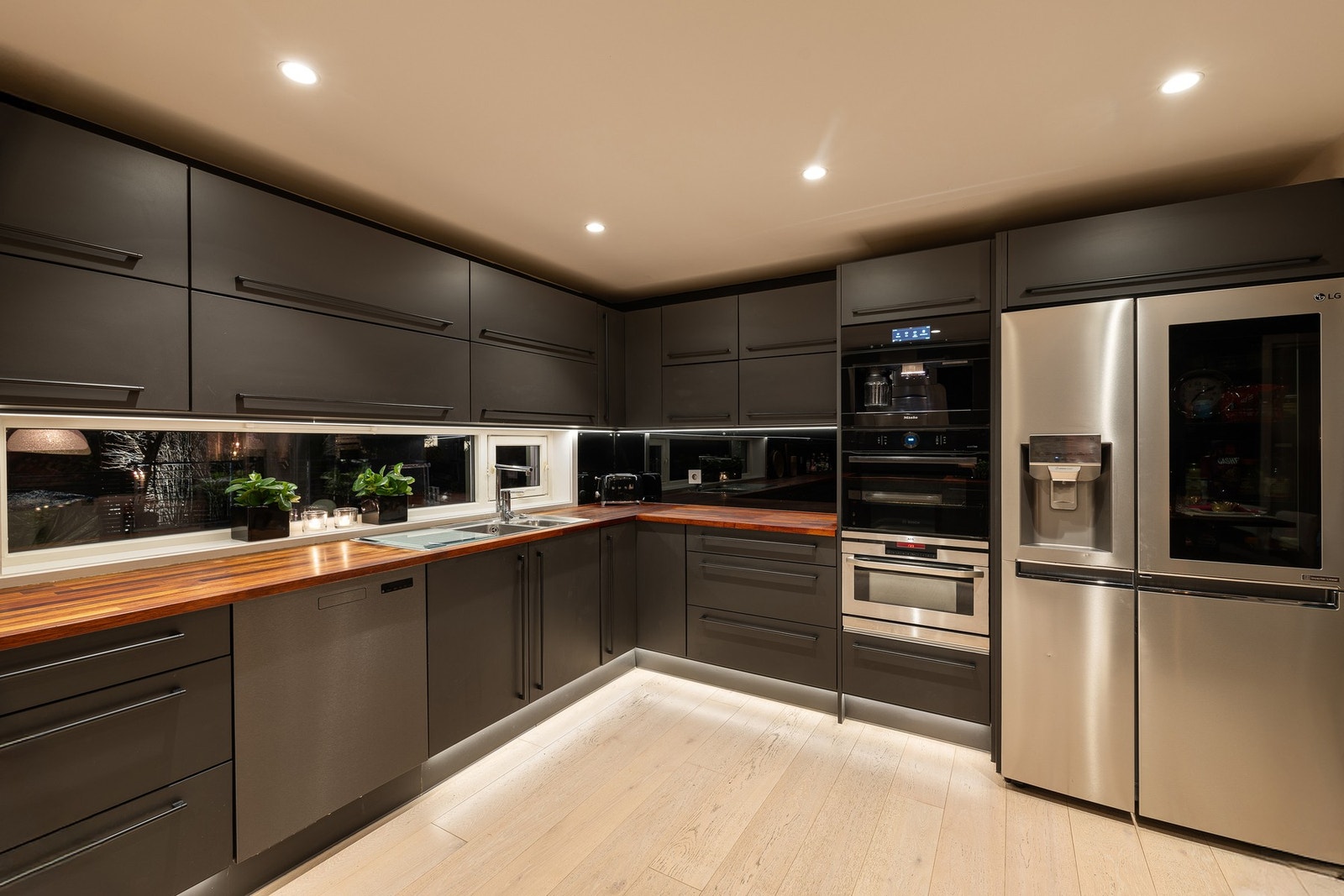 Den påkostede innredningen har integrerte hvitevarer. Avlange vinduer vender ut mot egen uteplass over garasje Galleribilde