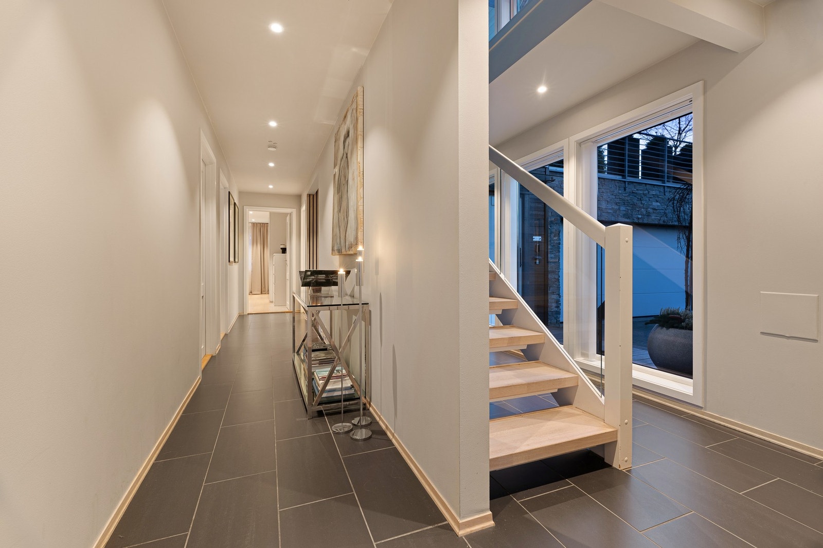 Hallen inkluderer et trappeløp mellom etasjeplan. Gangen innenfor leder til etasjens soverom og bad Galleribilde