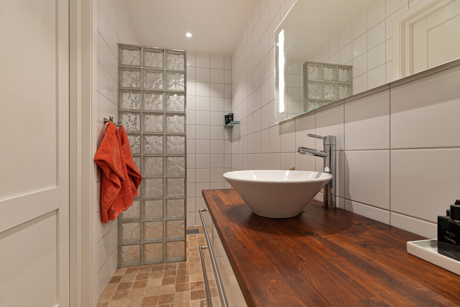 Det flislagte badet har dusjsone avgrenset med glassbyggerstein. Her er varmekabler i gulv Galleribilde