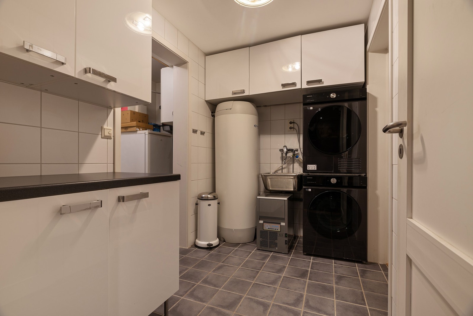 Et romslig vaskerom og bod/teknisk rom har sluse ut til garasje Galleribilde