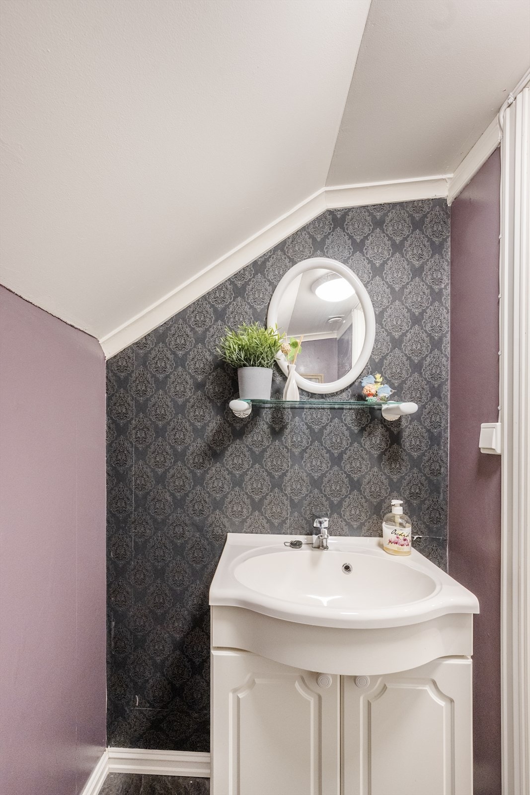 Toalettrommet er innredet med servant, speil og gulvmontert toalett. Galleribilde