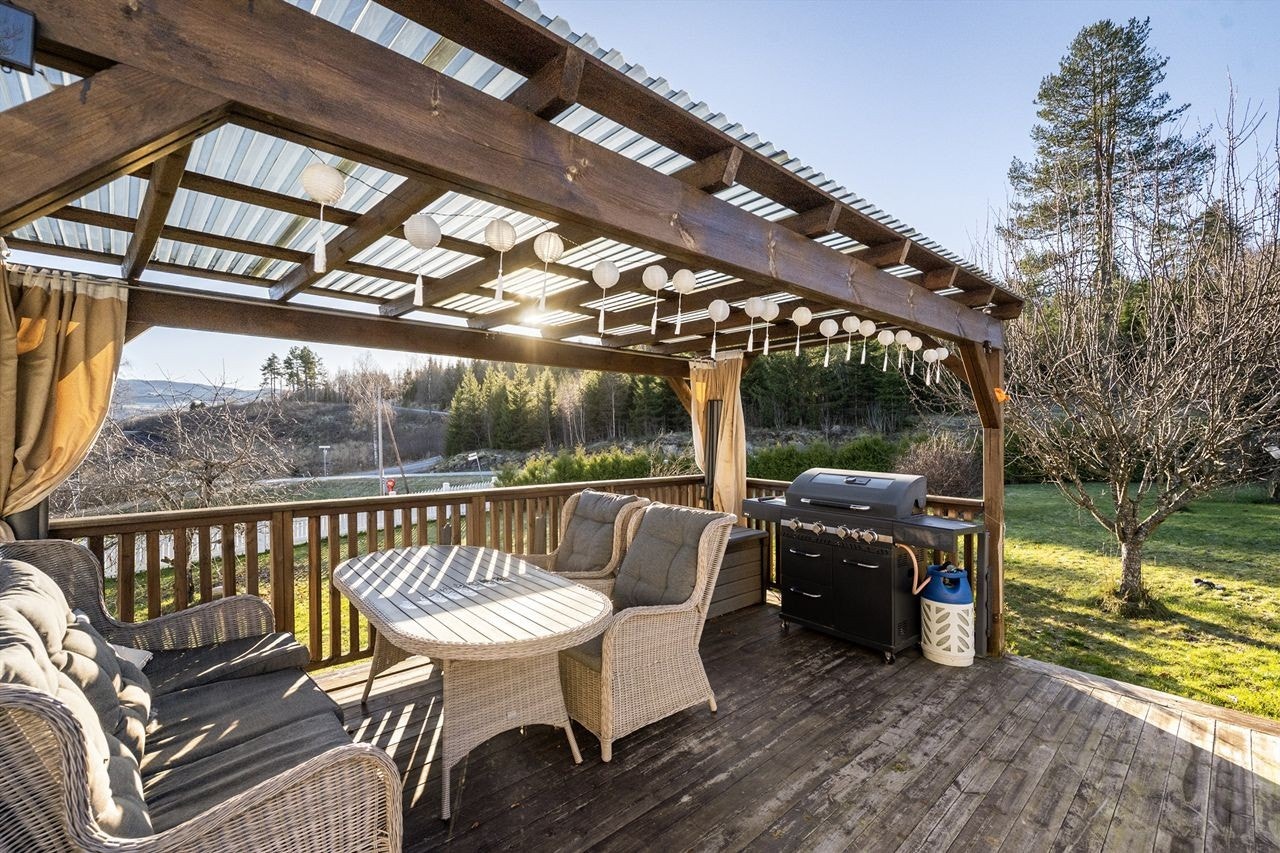 Pergolaen gir en lun og overbygd spiseplass på terrassen. Galleribilde