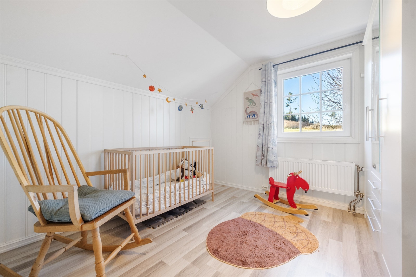 Et lyst og trivelig barnerom med plass til både seng og lekeareal. Galleribilde