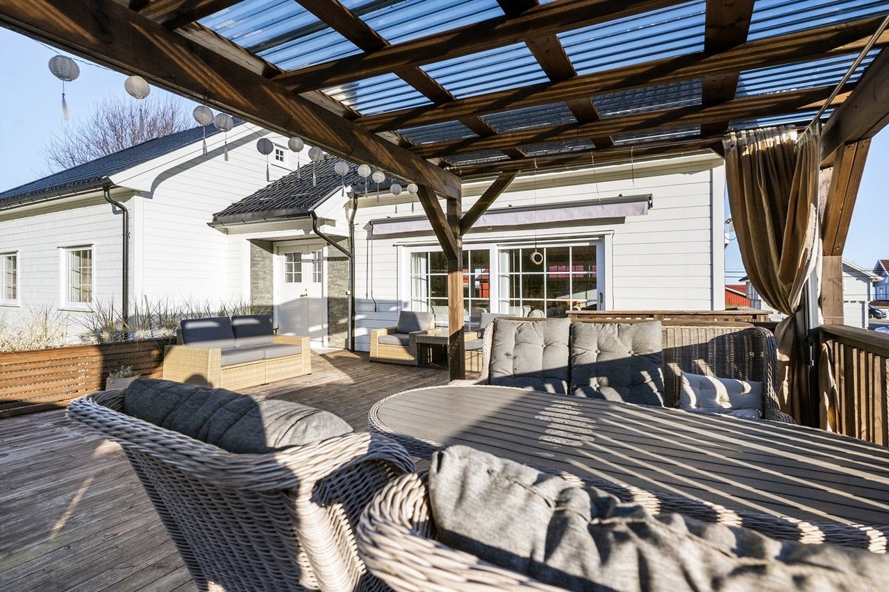 Terrassen har direkte tilknytning til stuen via skyvedør, noe som utvider det sosiale arealet om sommeren. Galleribilde