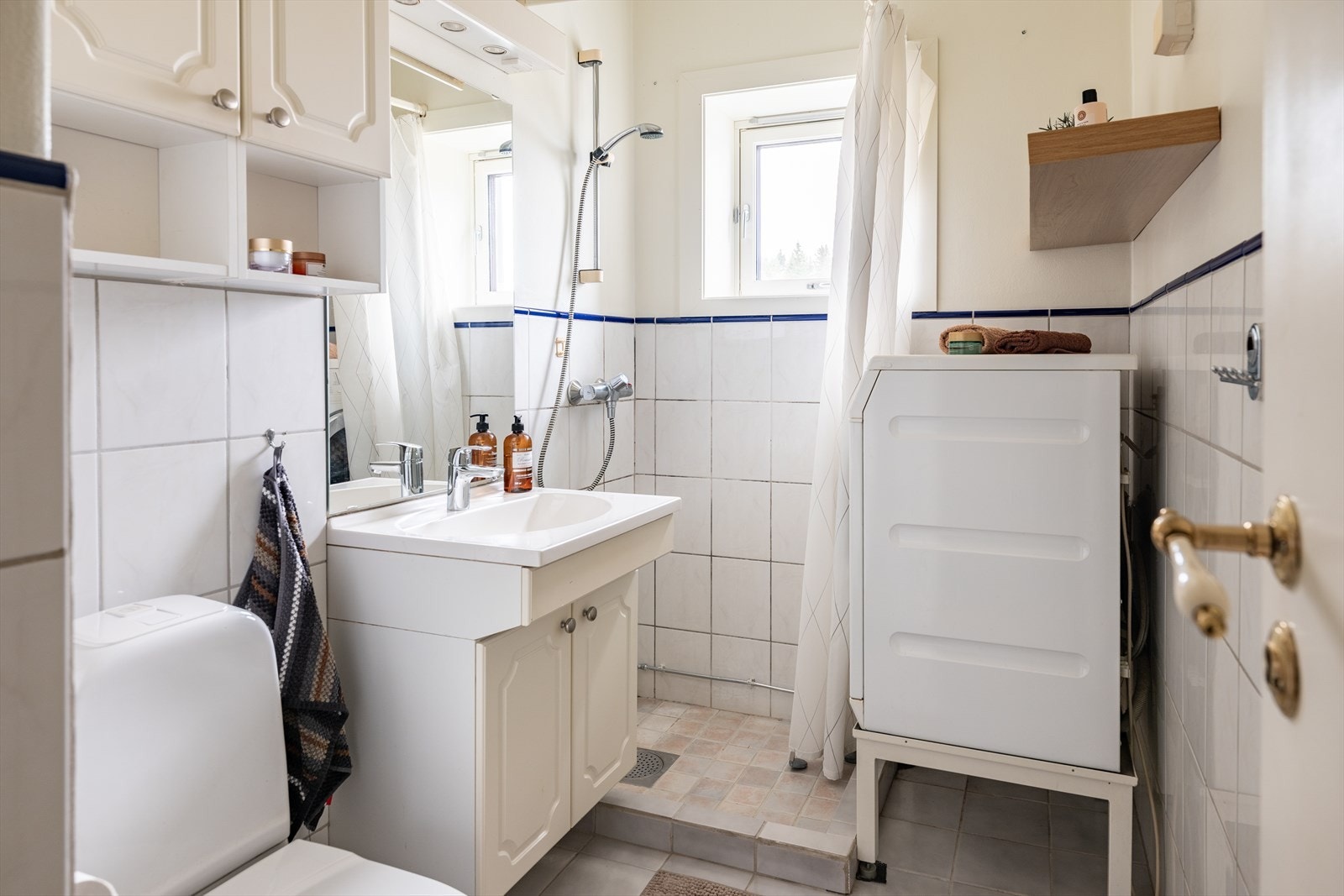 Badet er utstyrt med servant, dusjhjørne og opplegg for vaskemaskin. Galleribilde