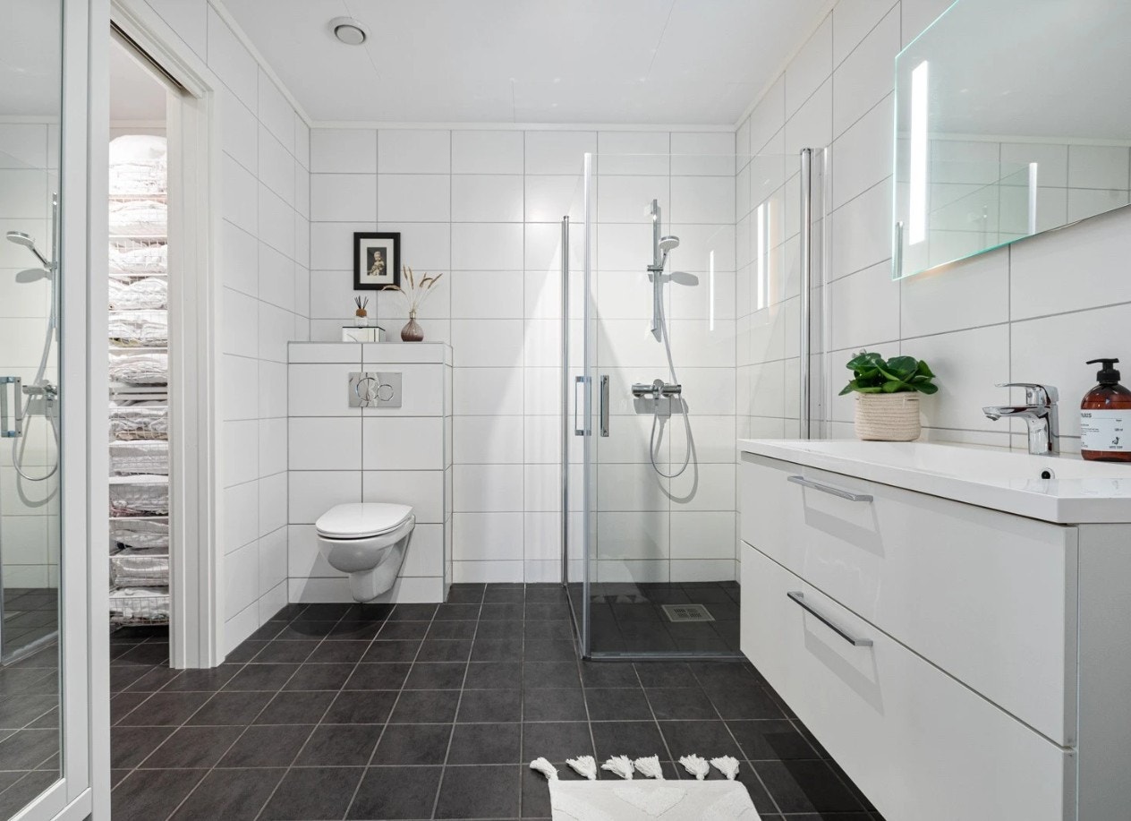 Romslig flislagt bad utstyrt med behagelig gulvvarme Galleribilde