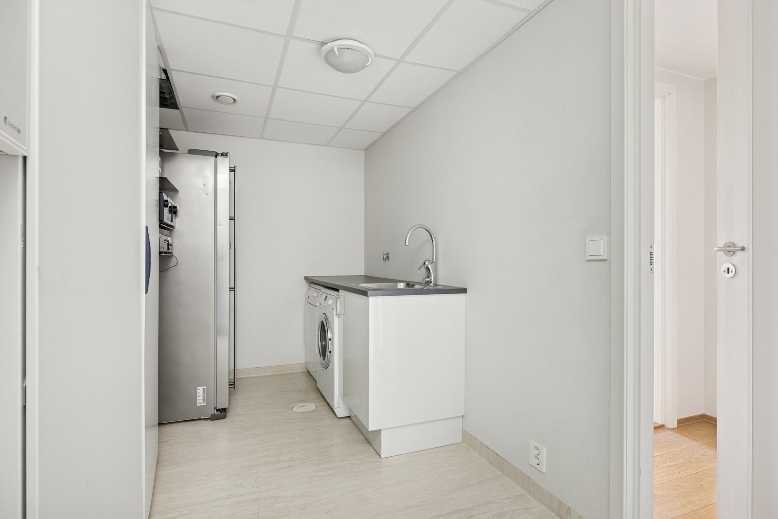 Vaskerom / teknisk rom. Skyllekum i innredning og opplegg for vaskemaskin og tørketrommel. Praktisk rom med plass for oppbevaring Galleribilde