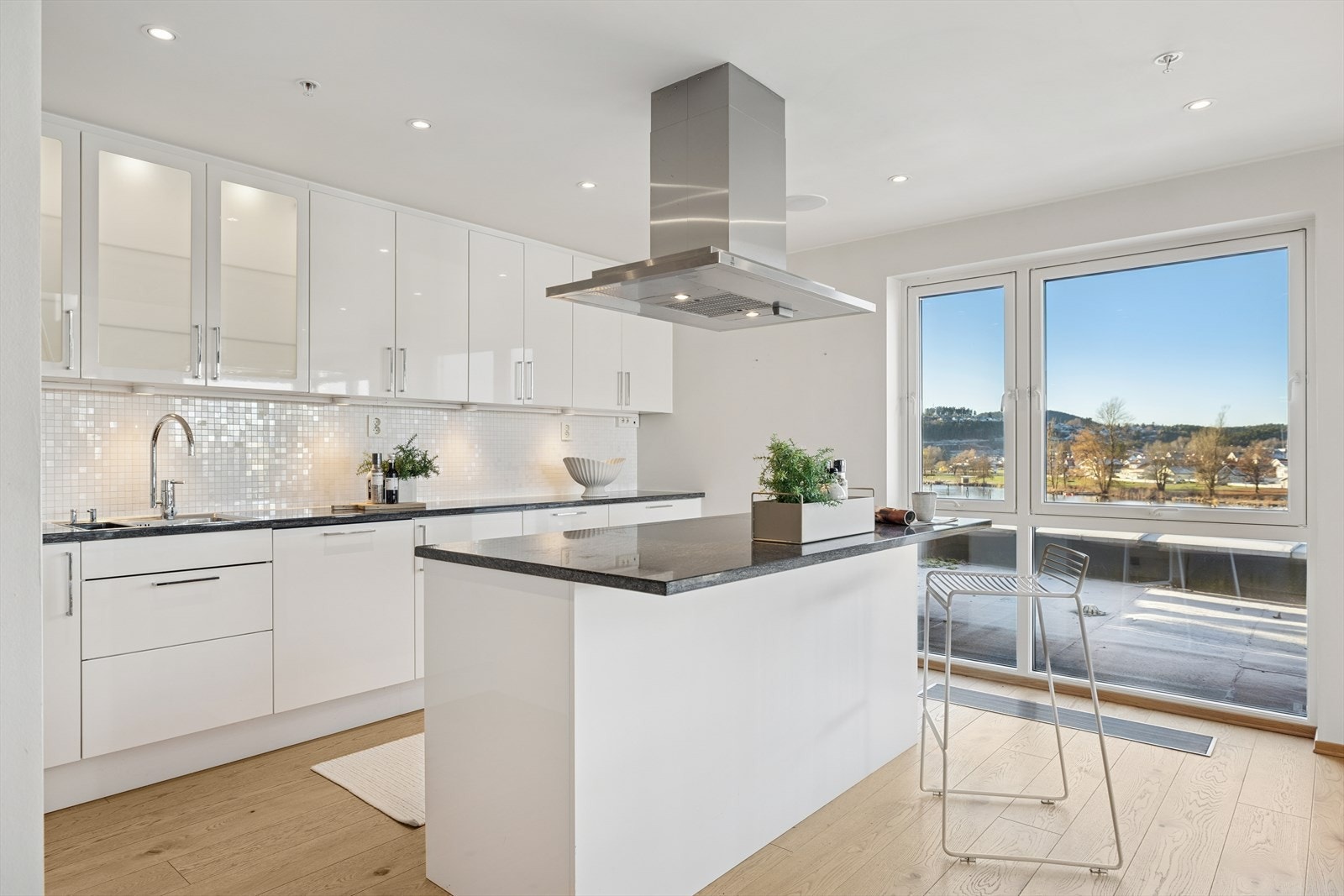 Kjøkkenet har mosaikfliser mellom over- og underskap, Rikelig med oppbevaring og meget godt benkeplass. Galleribilde