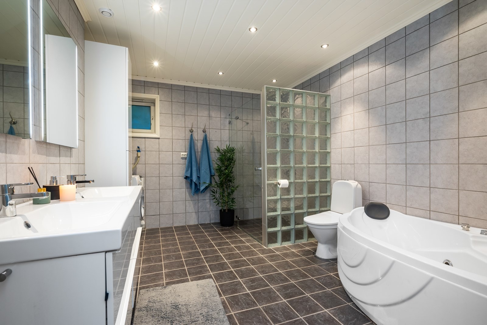 Badet er utstyrt med dusjnisje, vegghengt toalett og dobbel servantinnredning. Galleribilde